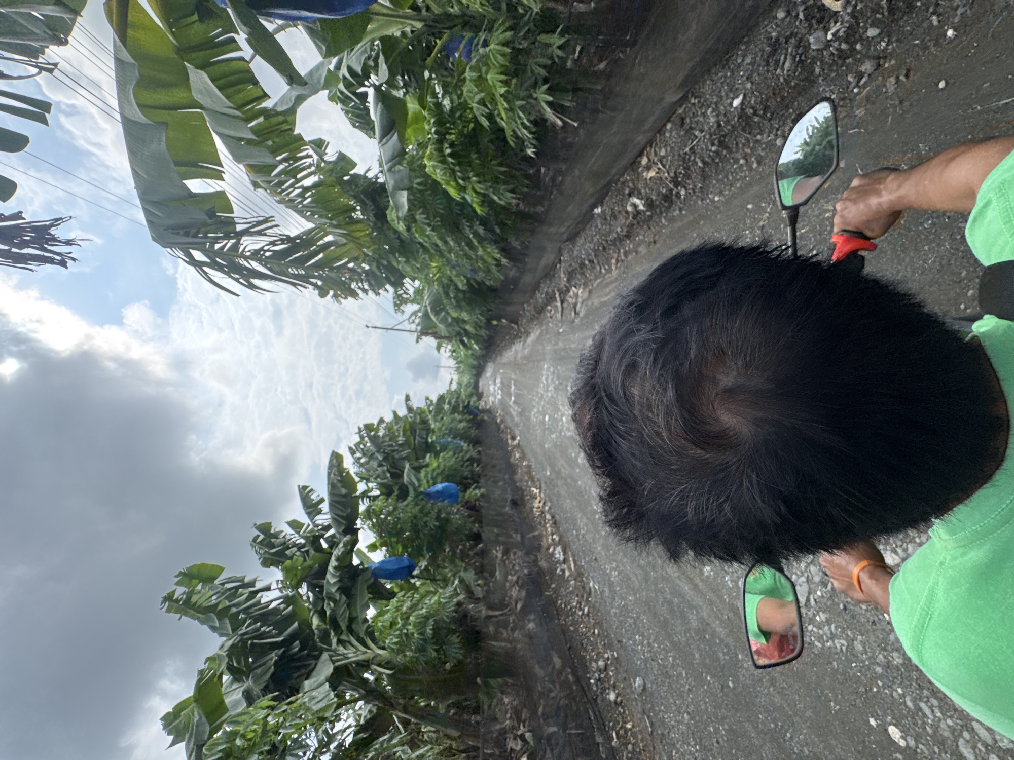 Motorcyclist travels rural dirt road in Carmen, Philippines