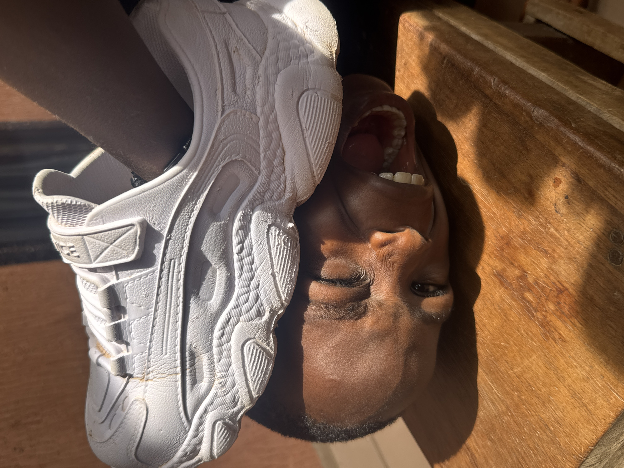 Child plays with soccer ball and sneakers in Onitsha