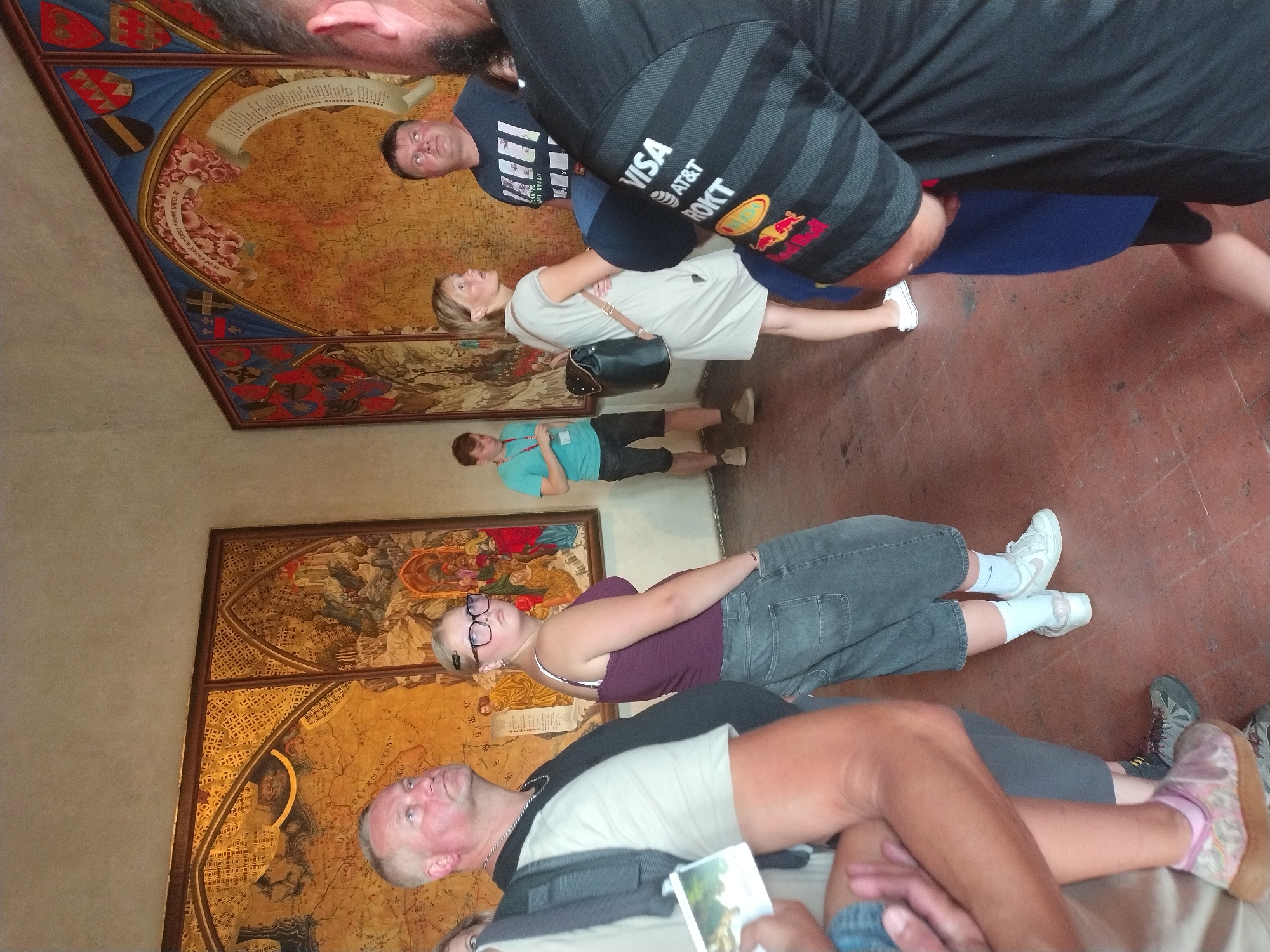 Touring a historic religious building with maps, altars, and old paintings