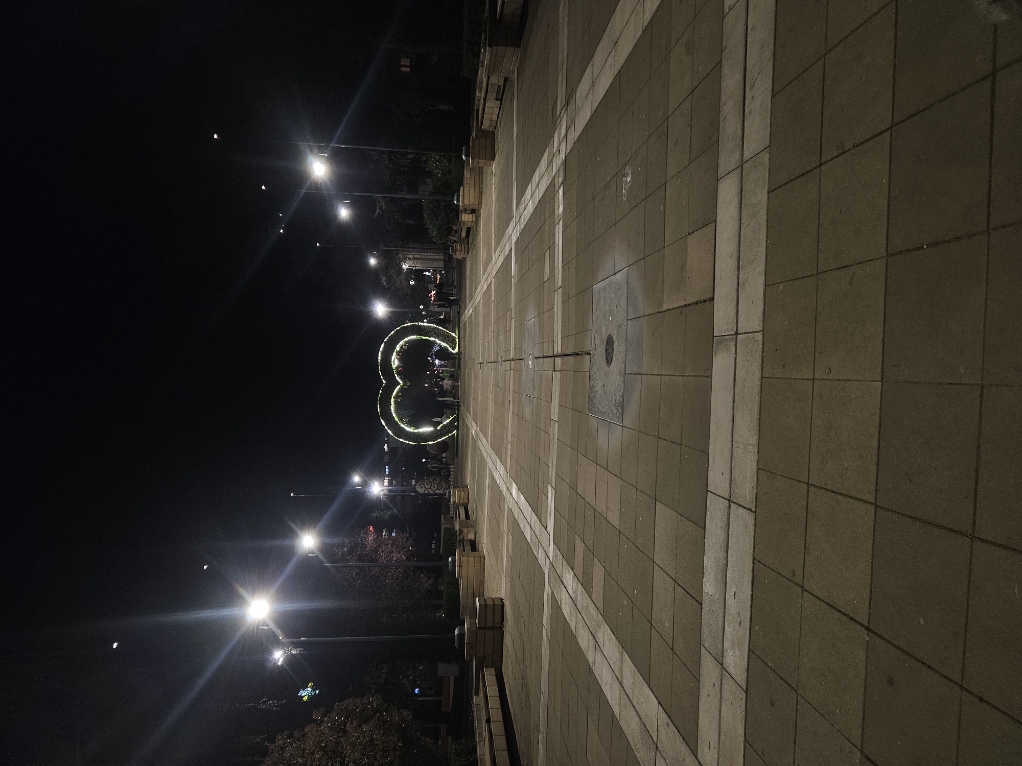 Evening stroll captured in Yambol plaza with illuminated decorations