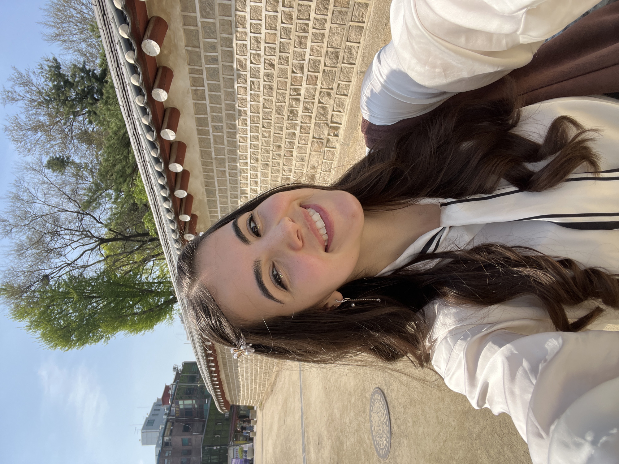 Woman takes morning selfies at traditional Seoul architecture