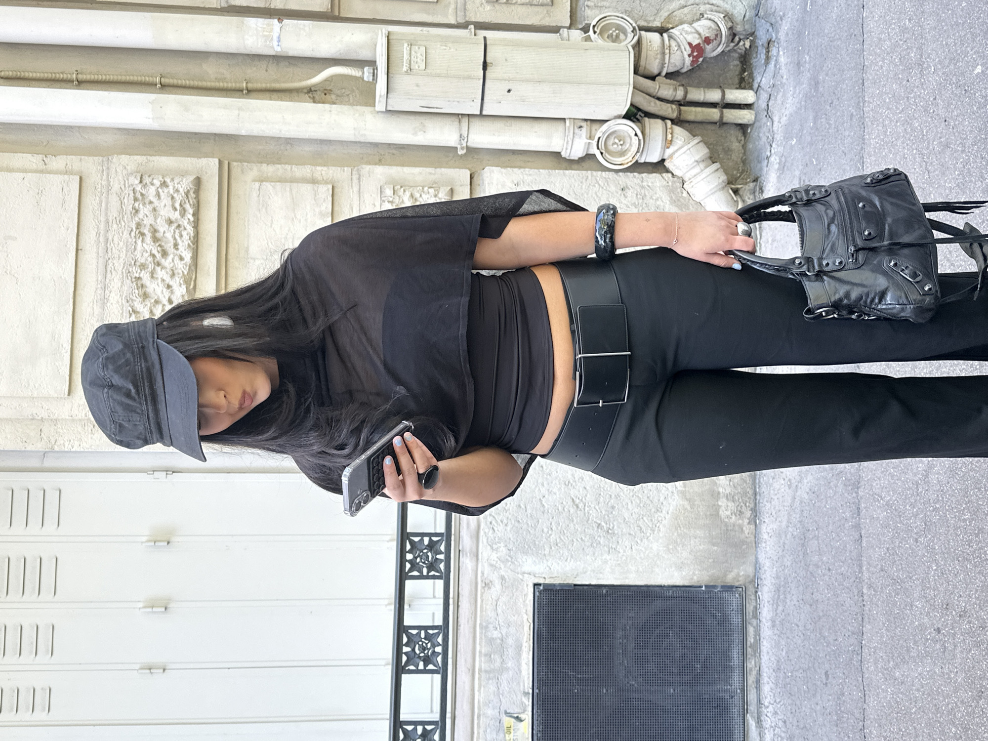 Paris street scenes: person in black, snake mural observed