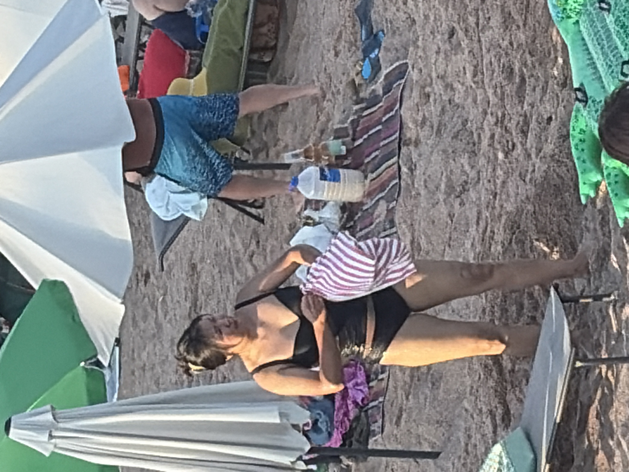 Crowded beach resort in full swing: pier, water sports, swimmers