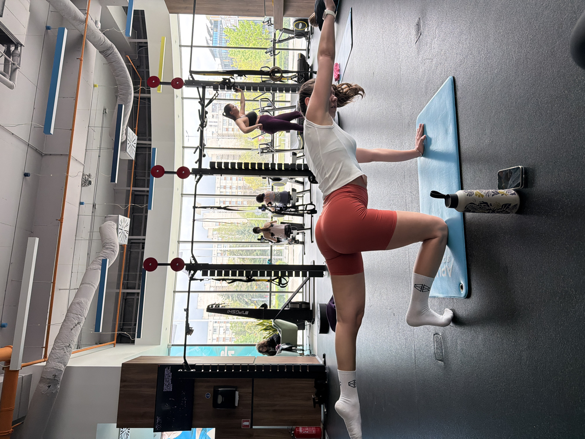 Woman exercises in bright daytime gym facility