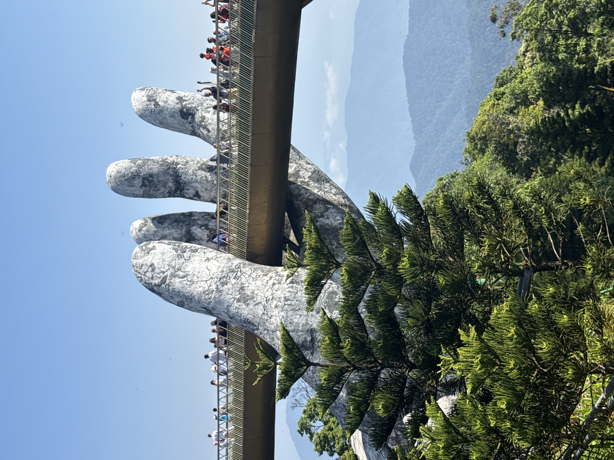 Tourists photograph iconic Golden Bridge and Buddha statue in Vietnam