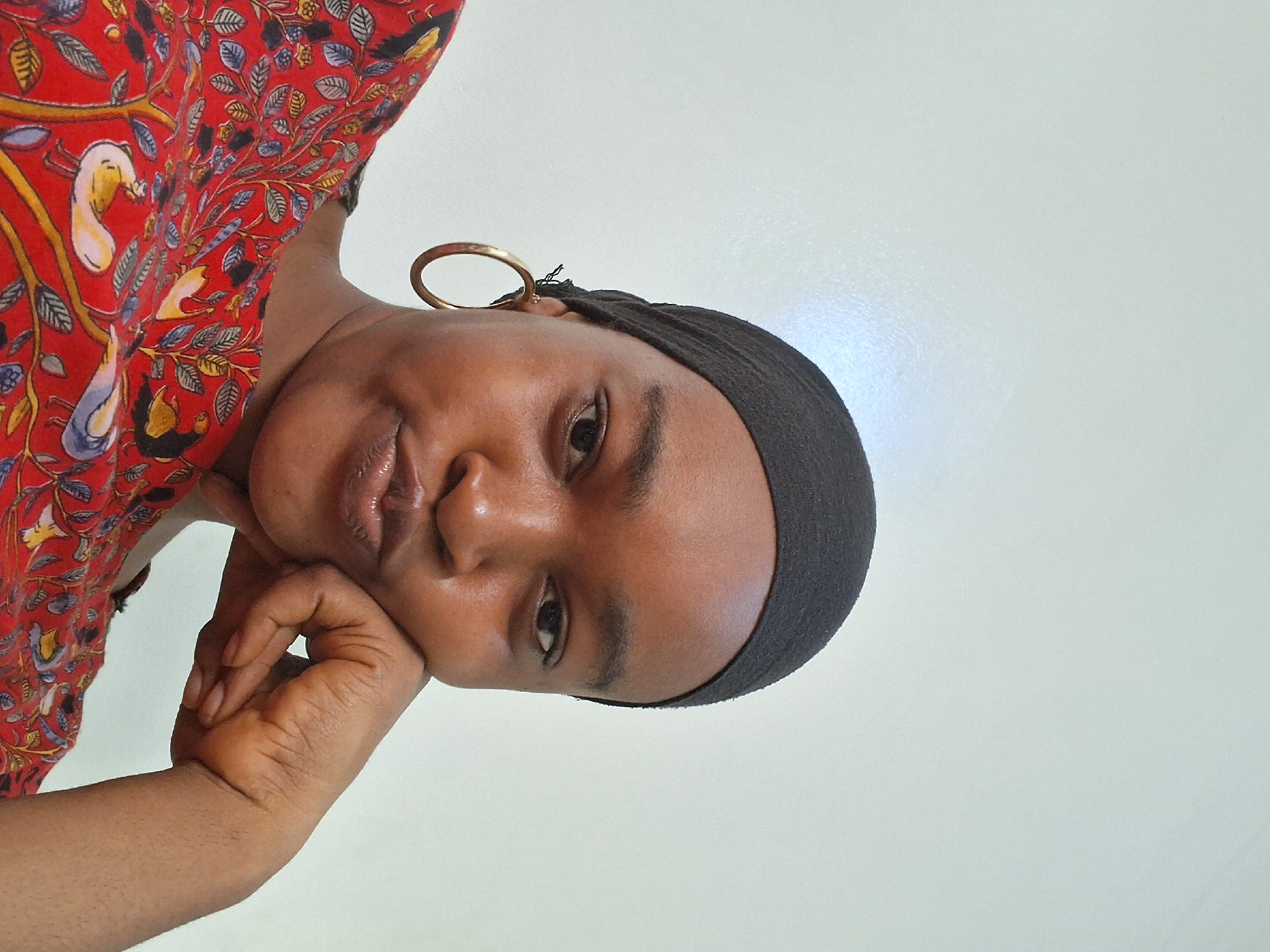 Woman in headscarf photographed near residential palm-lined neighborhood