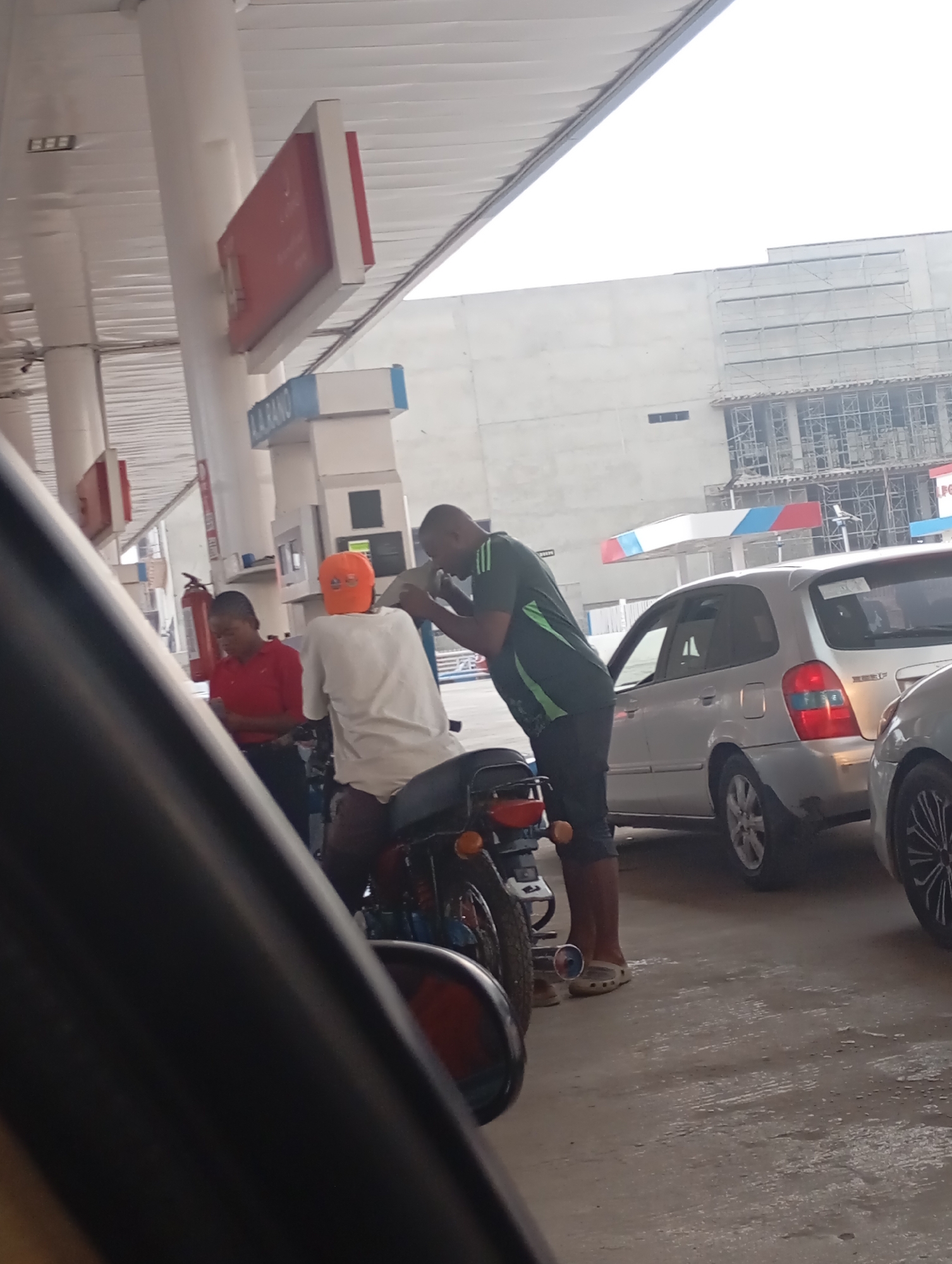 Men visit gas station in Abuja during morning hours