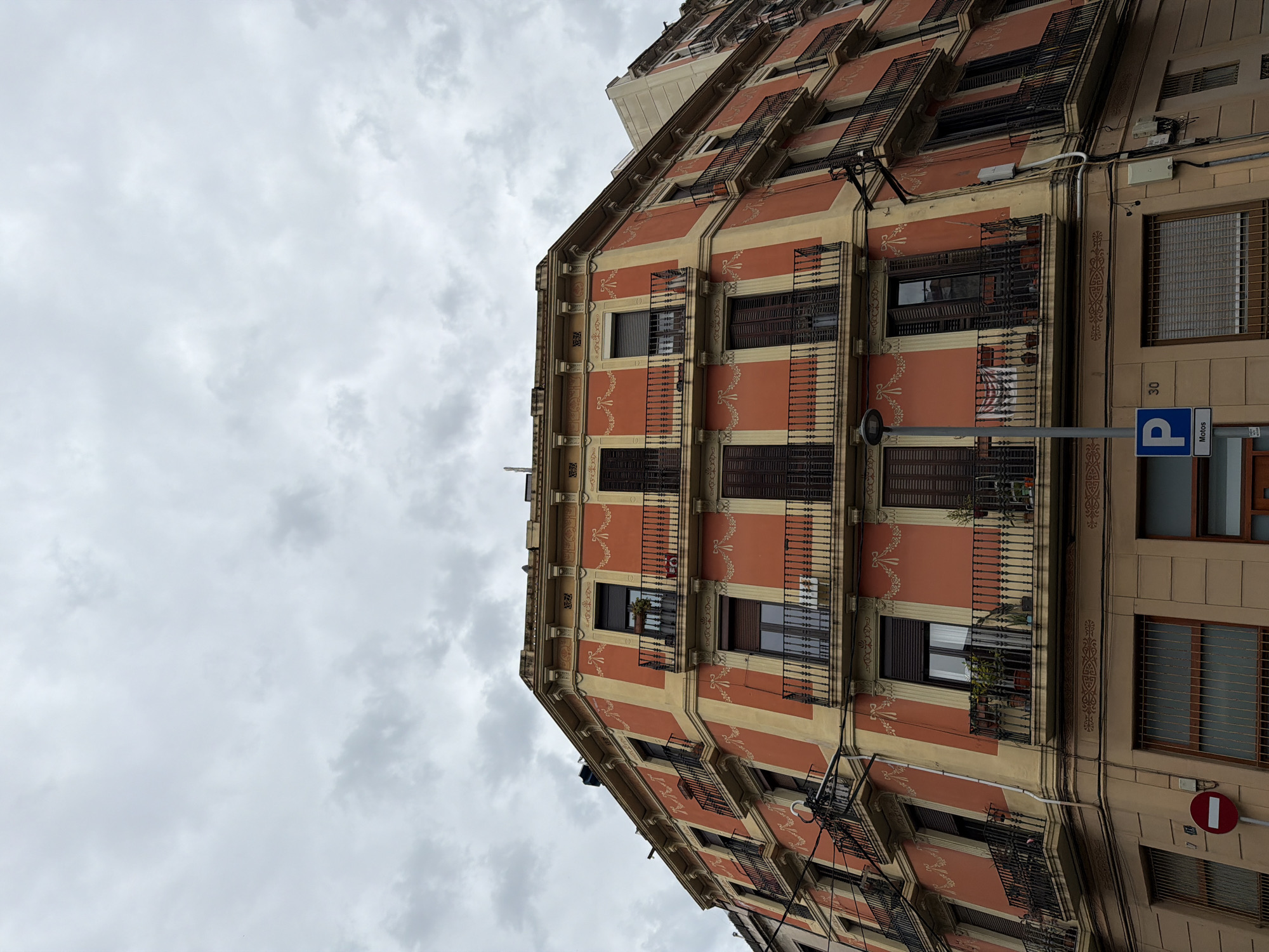 Terracotta building with cream stripes observed in Barcelona