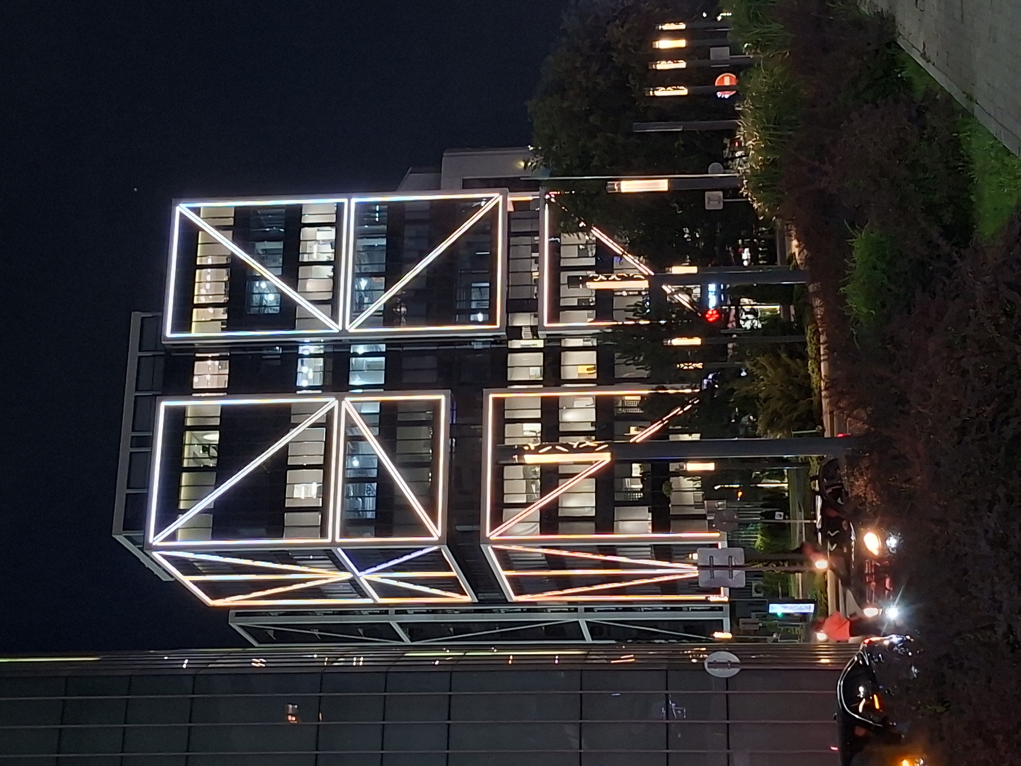 Almaty building glows at night with geometric neon lighting