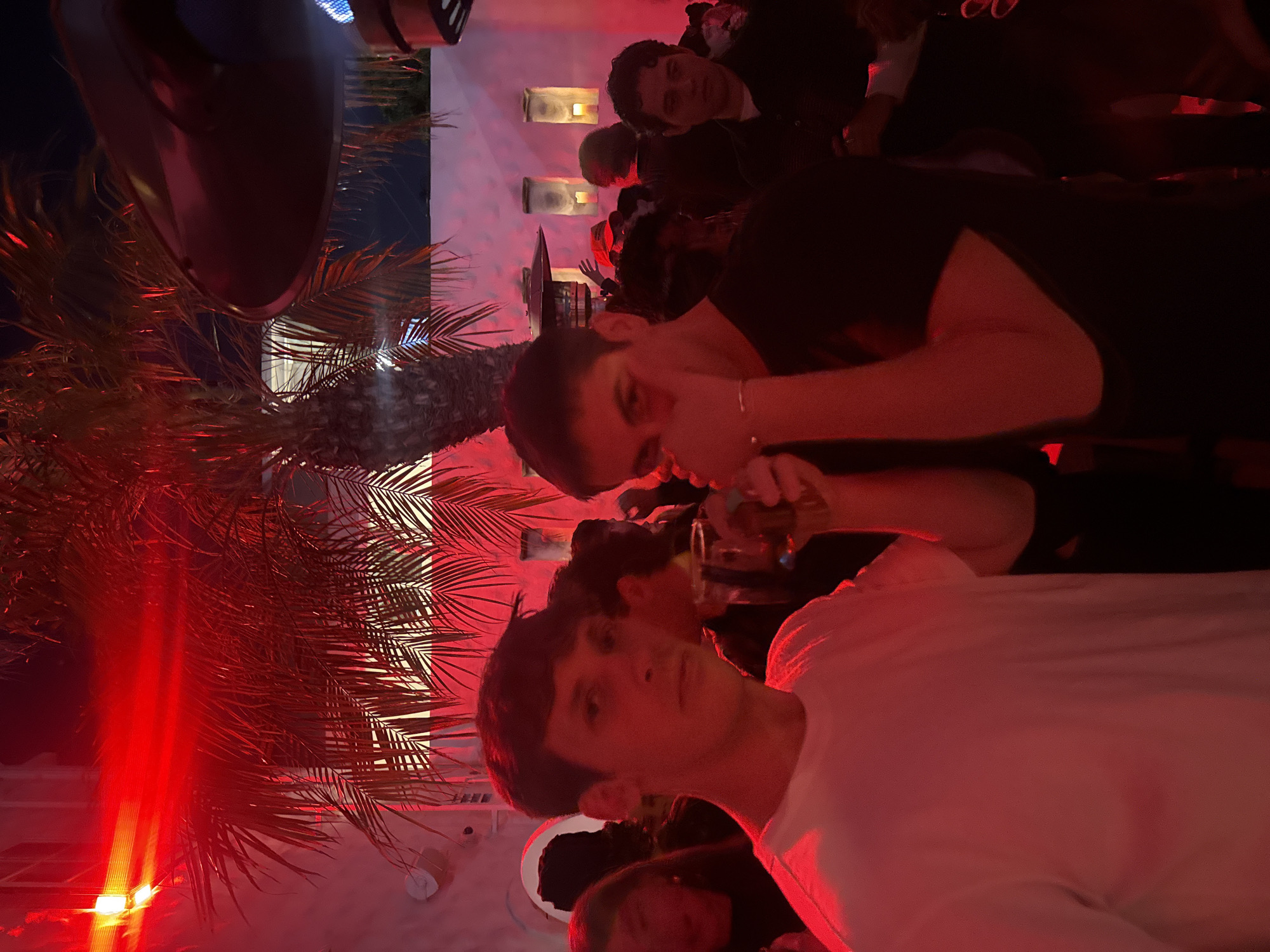 Group photographed under red lighting in Los Angeles at night