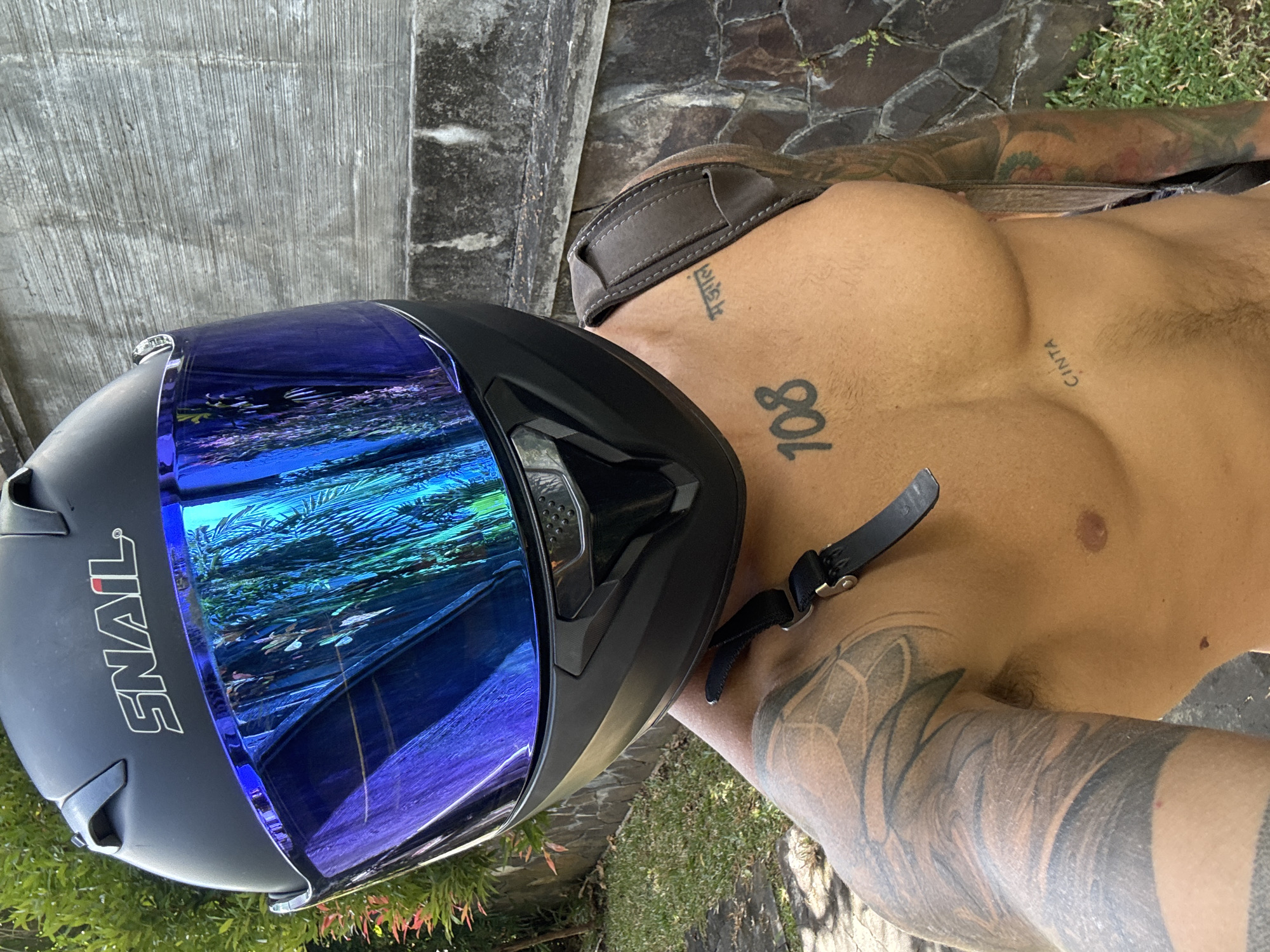 Tattooed rider poses with black helmet in Kuta Selatan