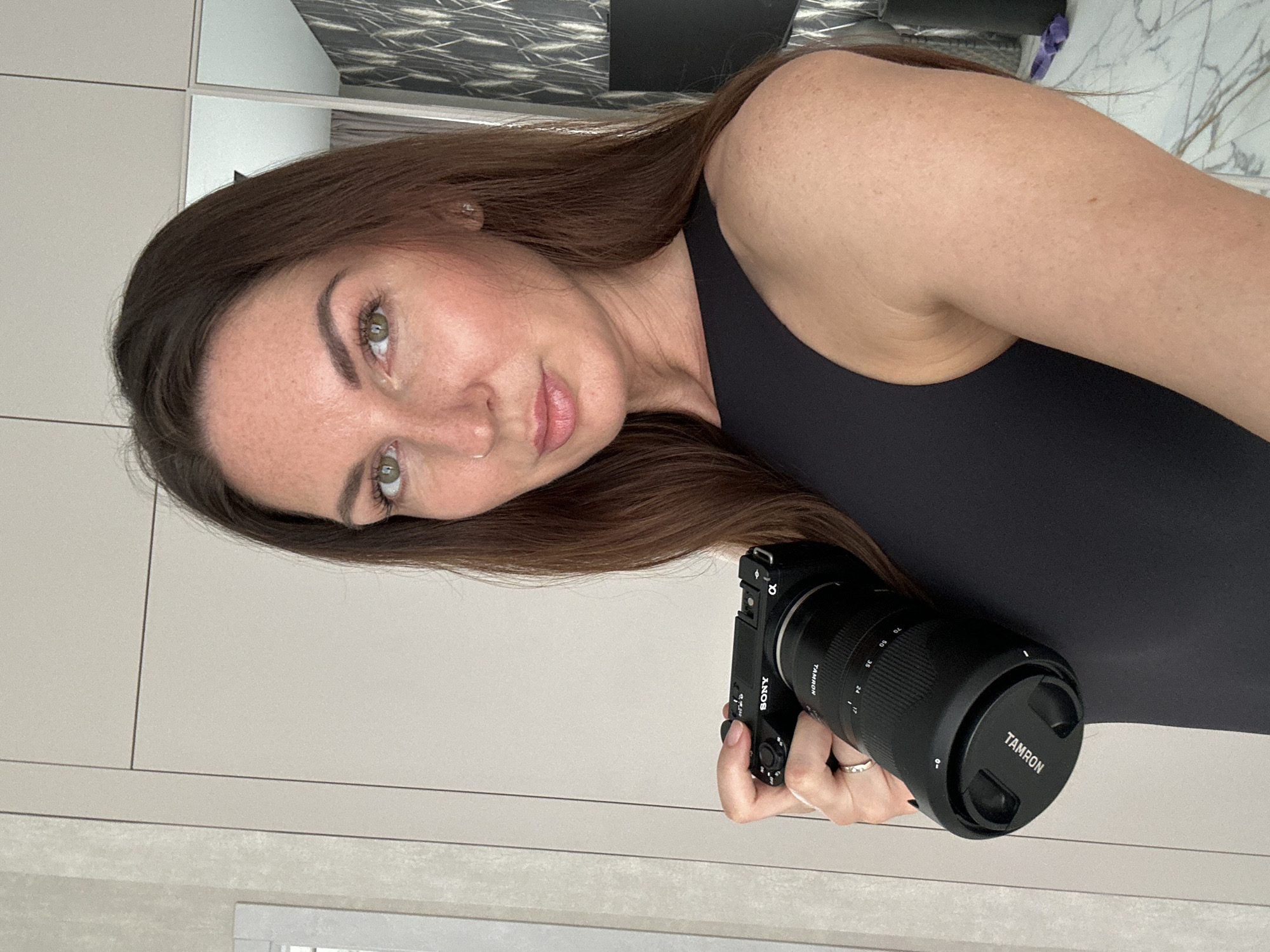 Woman takes mirror selfies with phone, camera in Chaikovsky