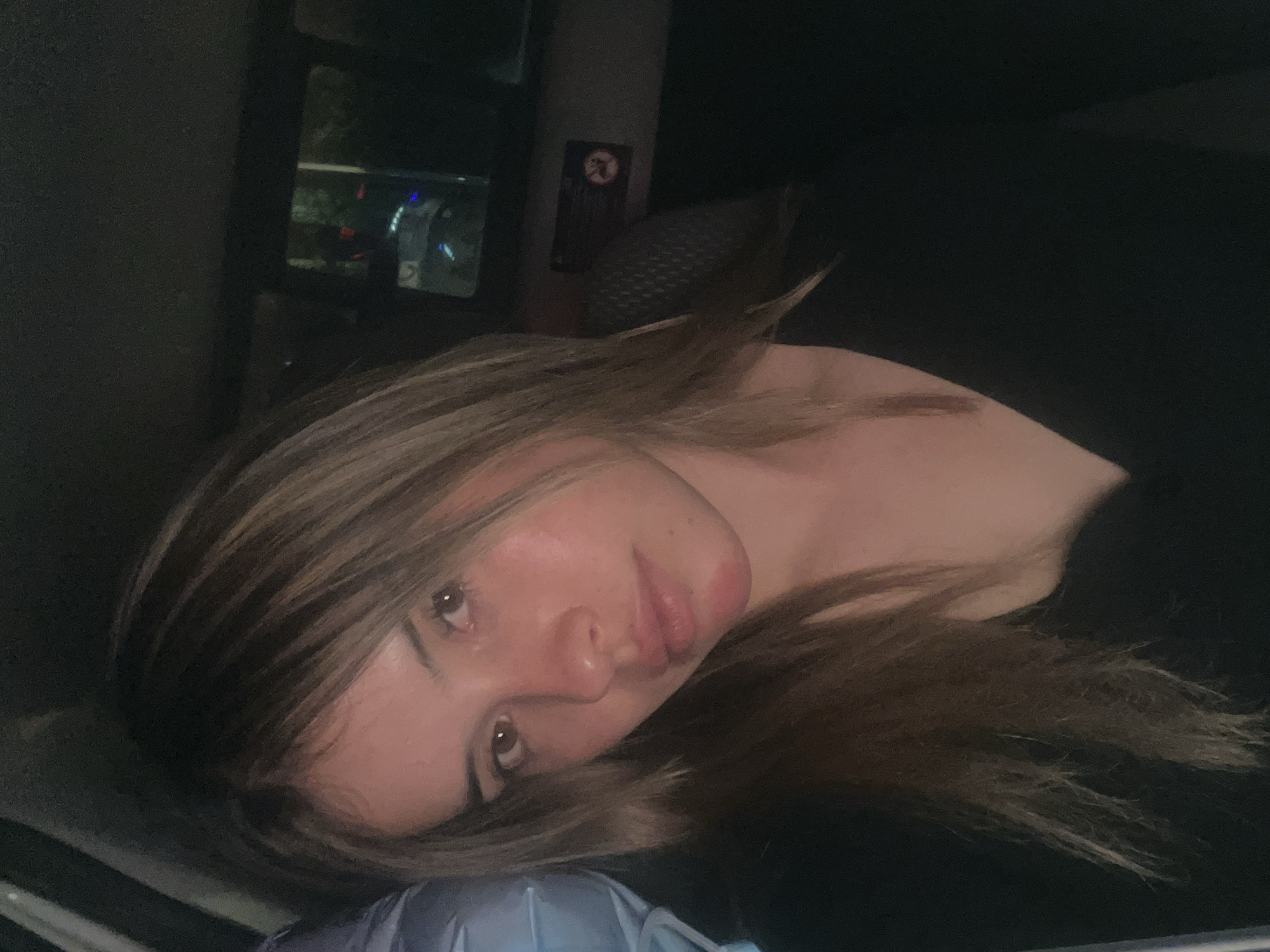 Woman rests with birthday balloon in car backseat
