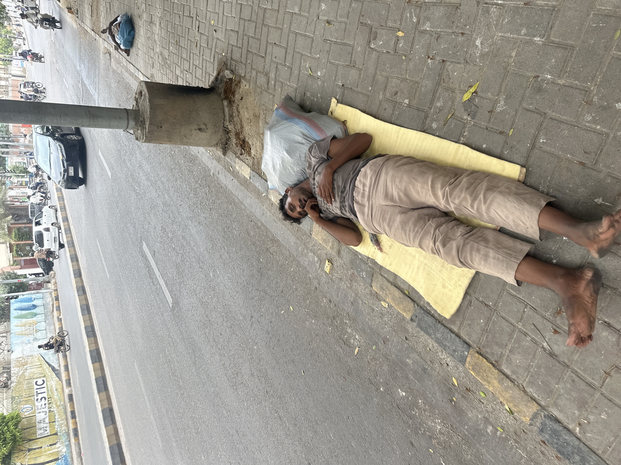 Sleeping on Karachi sidewalks on a July morning