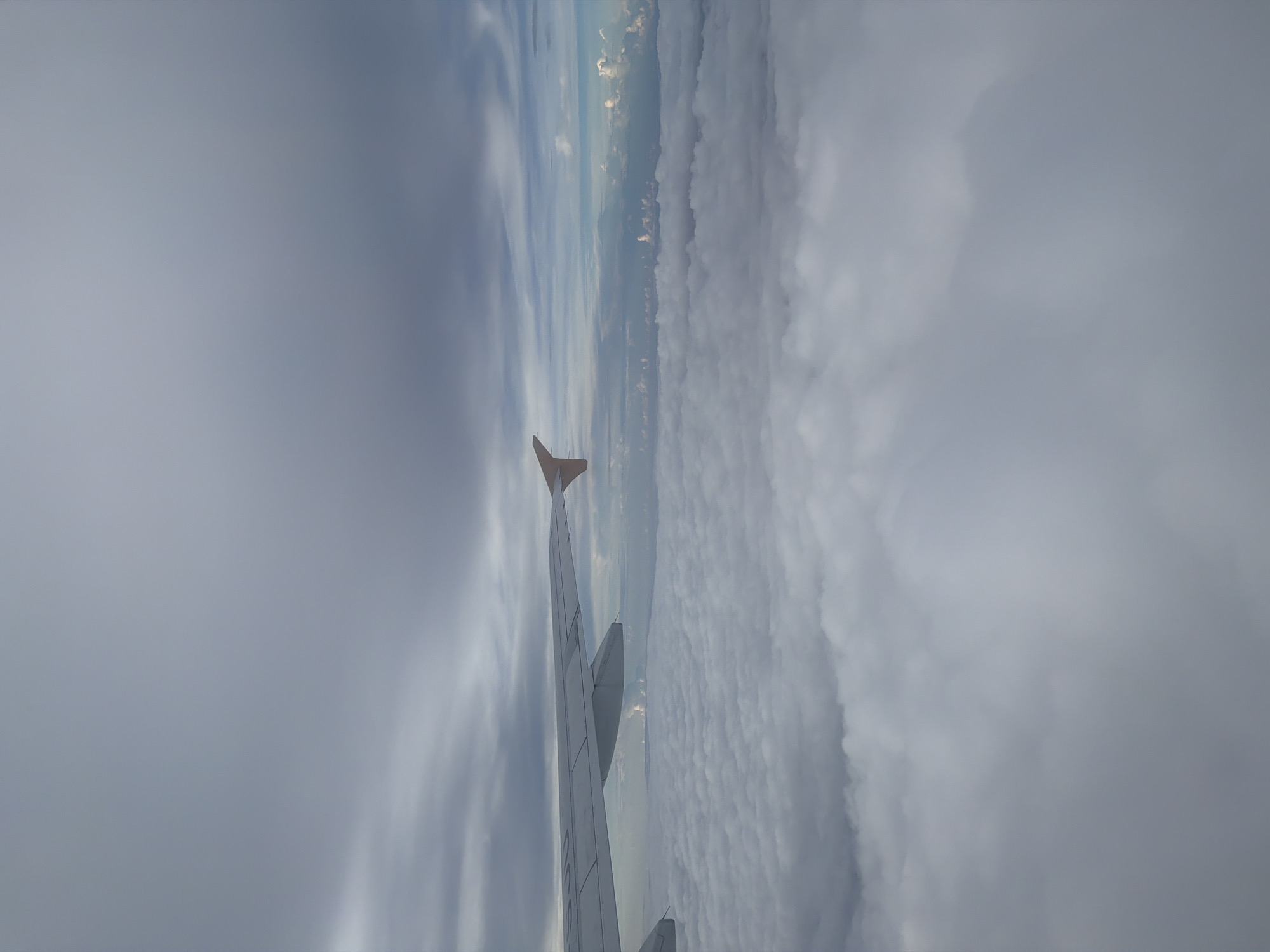 Passenger documents flight over cloudy Indonesian skies