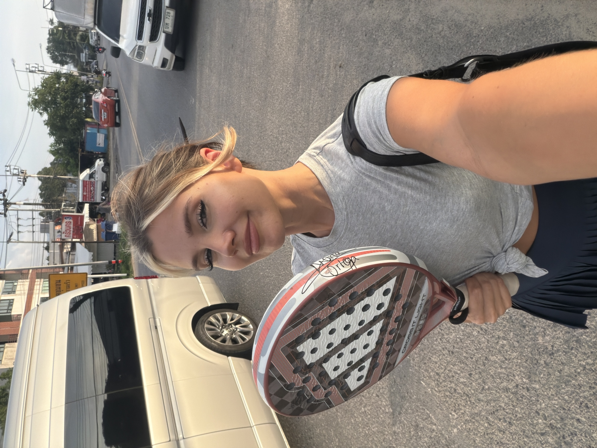 Padel racket in hand on a Thep Krasatti street