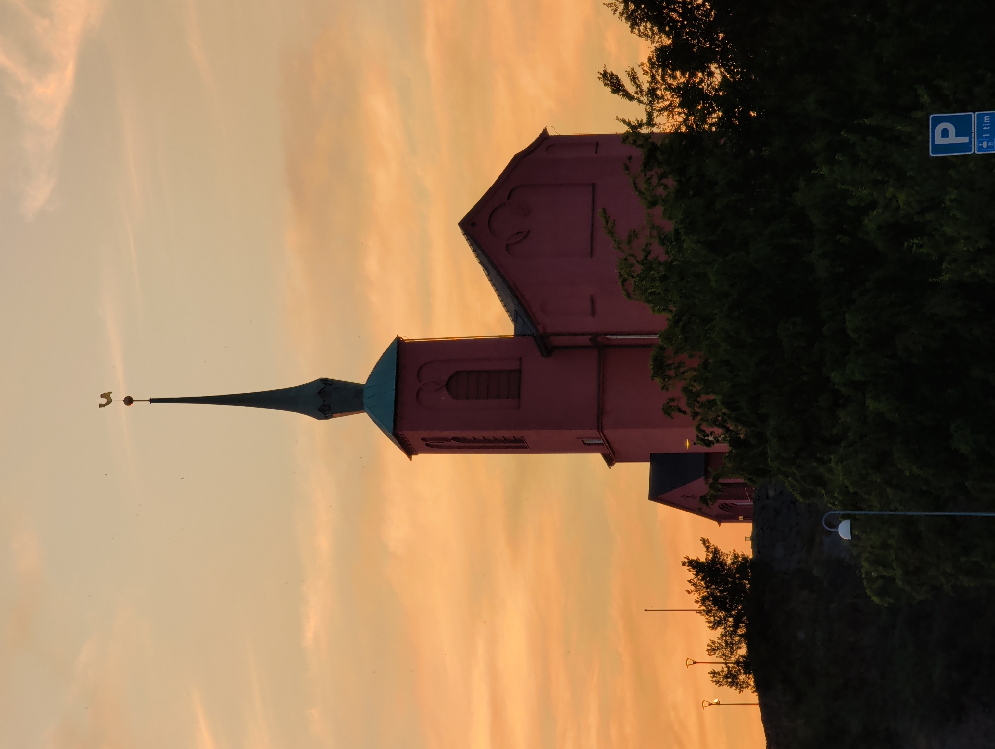 Pink church silhouetted against a warm evening sky in Nynäshamn