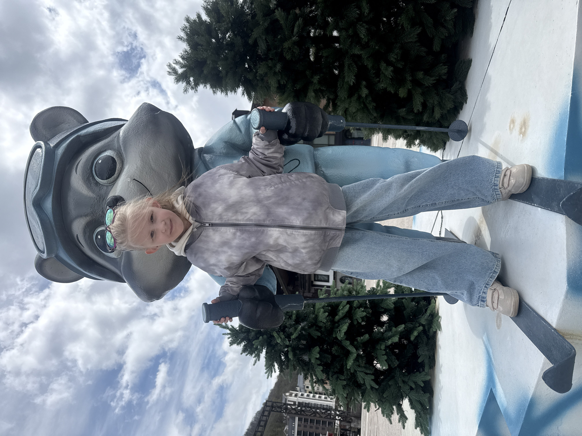 Girl poses with skiing character statue in Estosadok