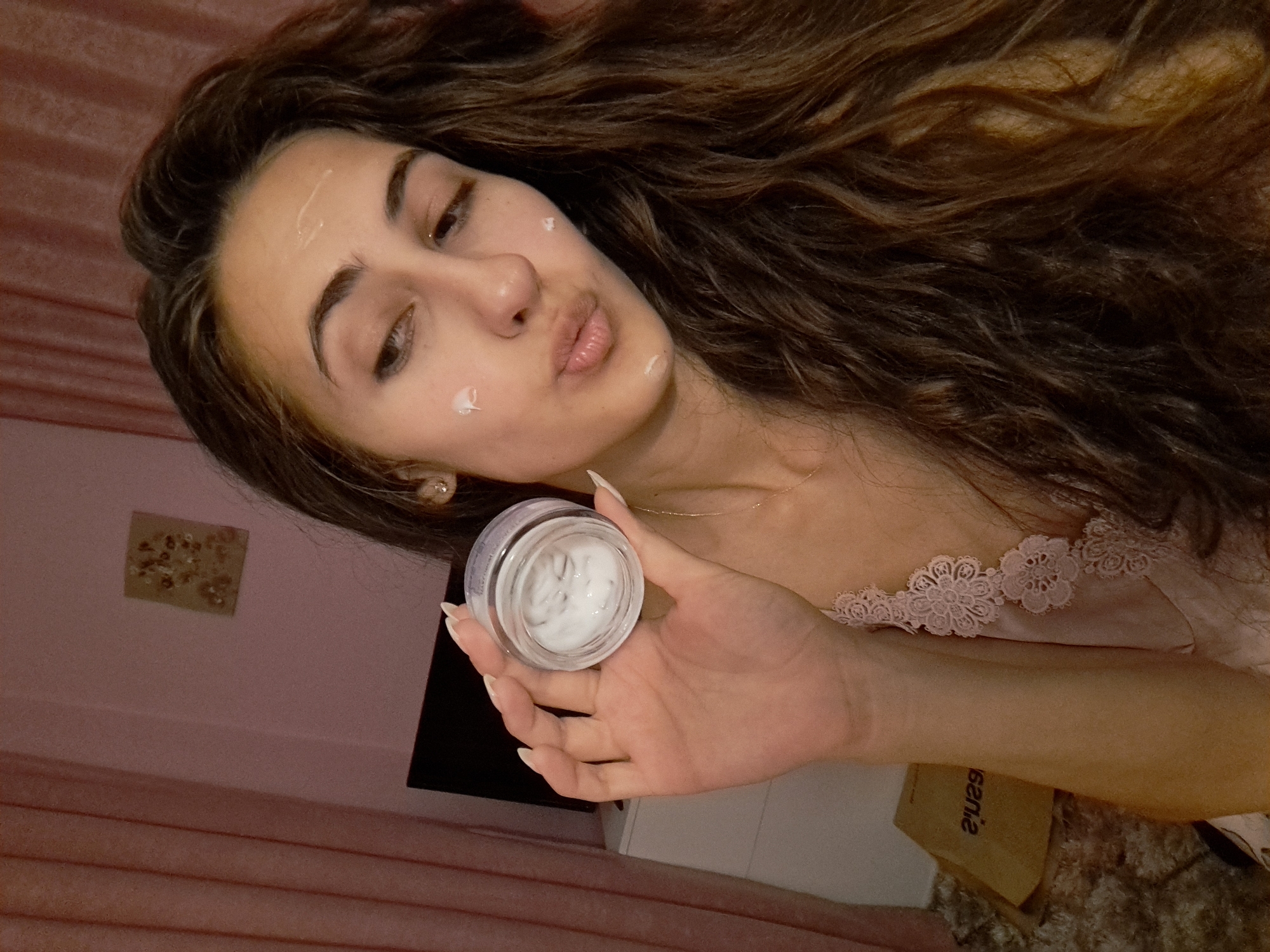 Woman demonstrates nighttime skincare routine with L'Oréal cream