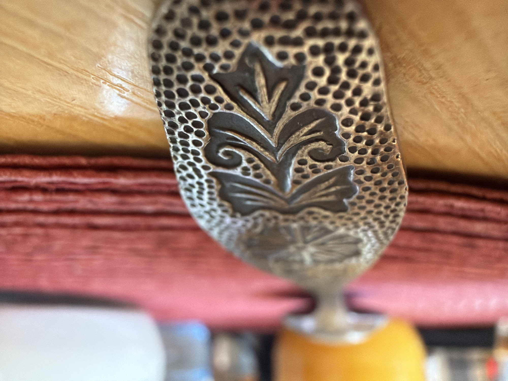 Ornate silver object photographed on pink fabric in Velingrad