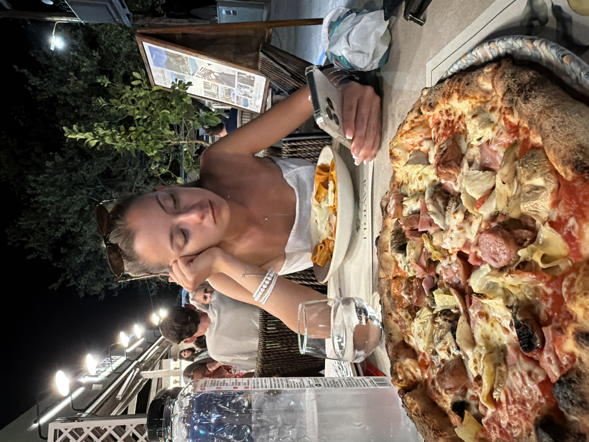 Pizza and phone time at a Greek restaurant terrace
