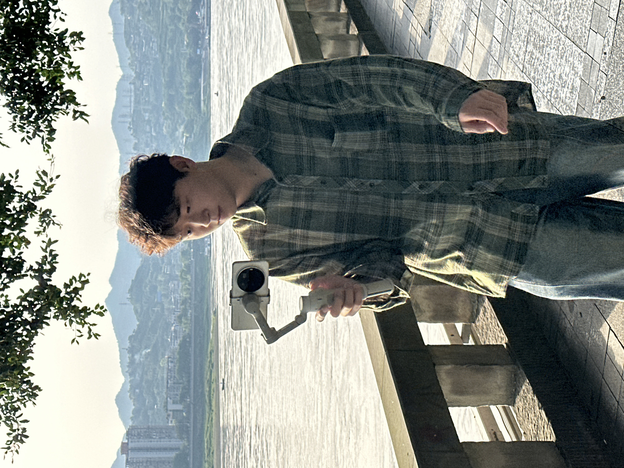 People gather with filming equipment on Jiangjin waterfront promenade