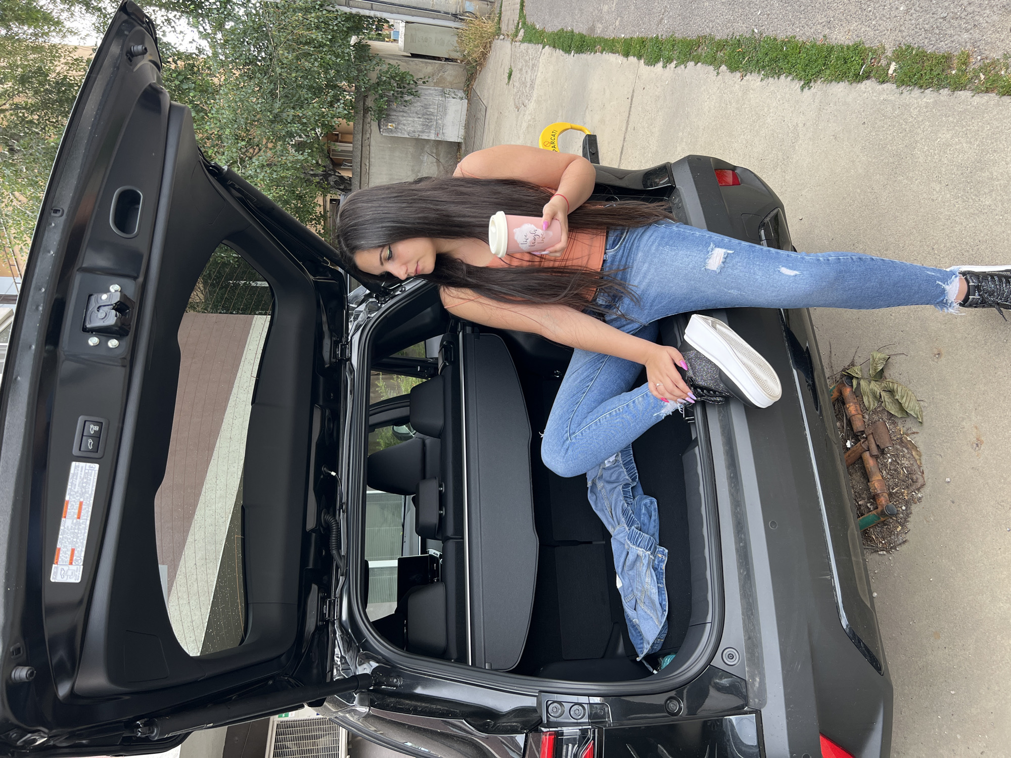 Chilling in an SUV trunk with a drink, Sofia