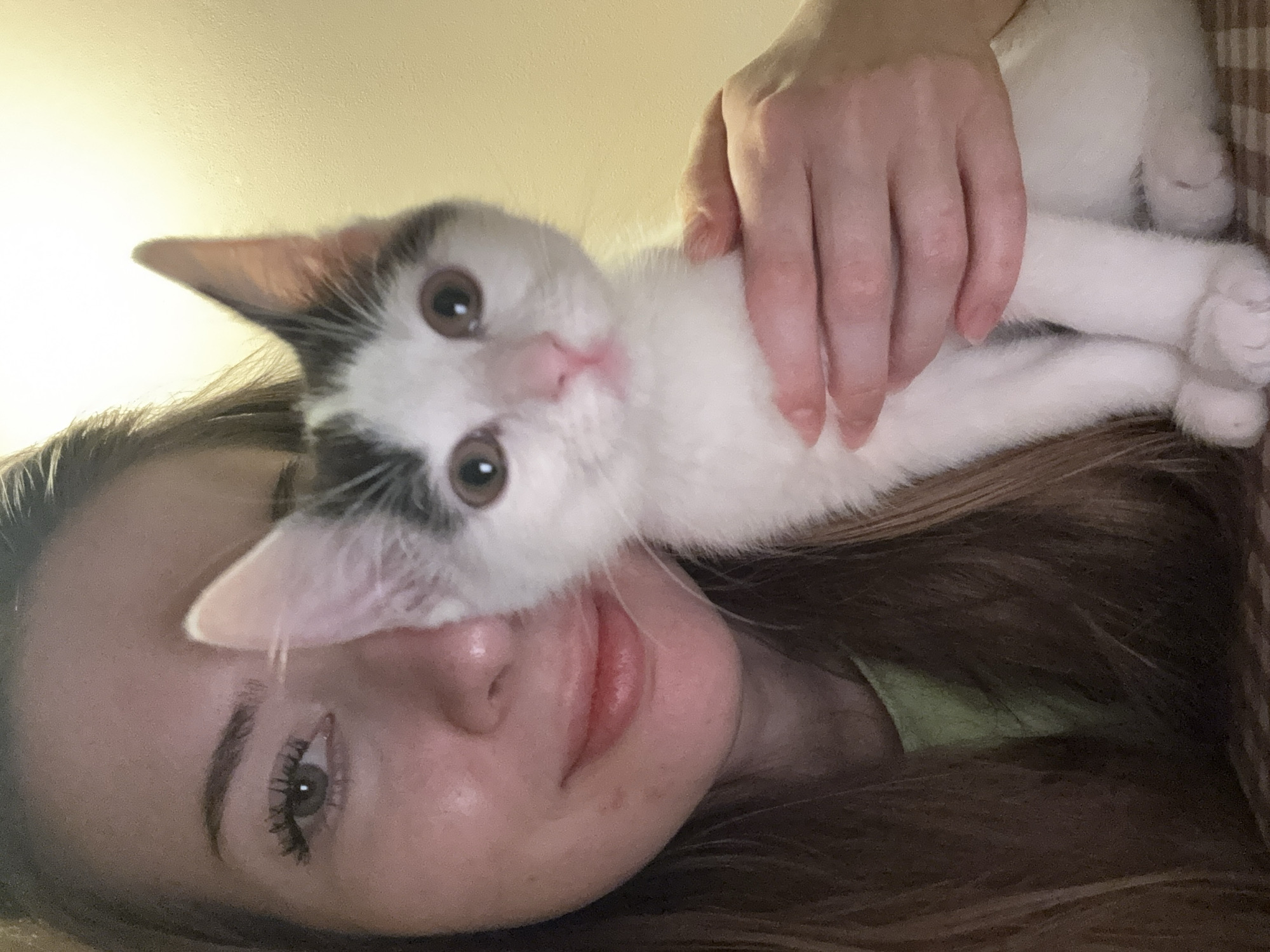 Woman poses with kitten in sideways portrait in Łódź