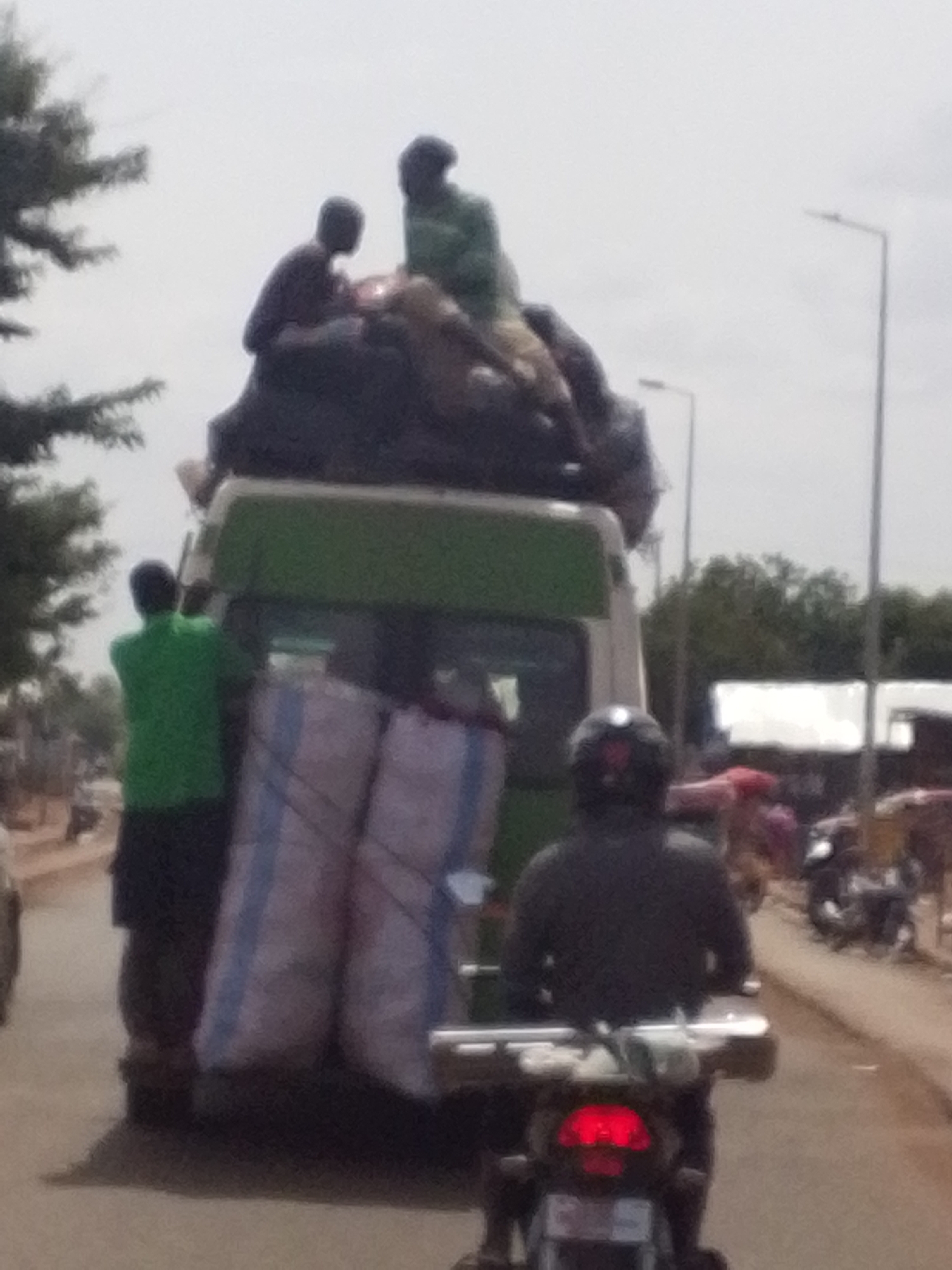 Overloaded van carries roof passengers through Tamale streets
