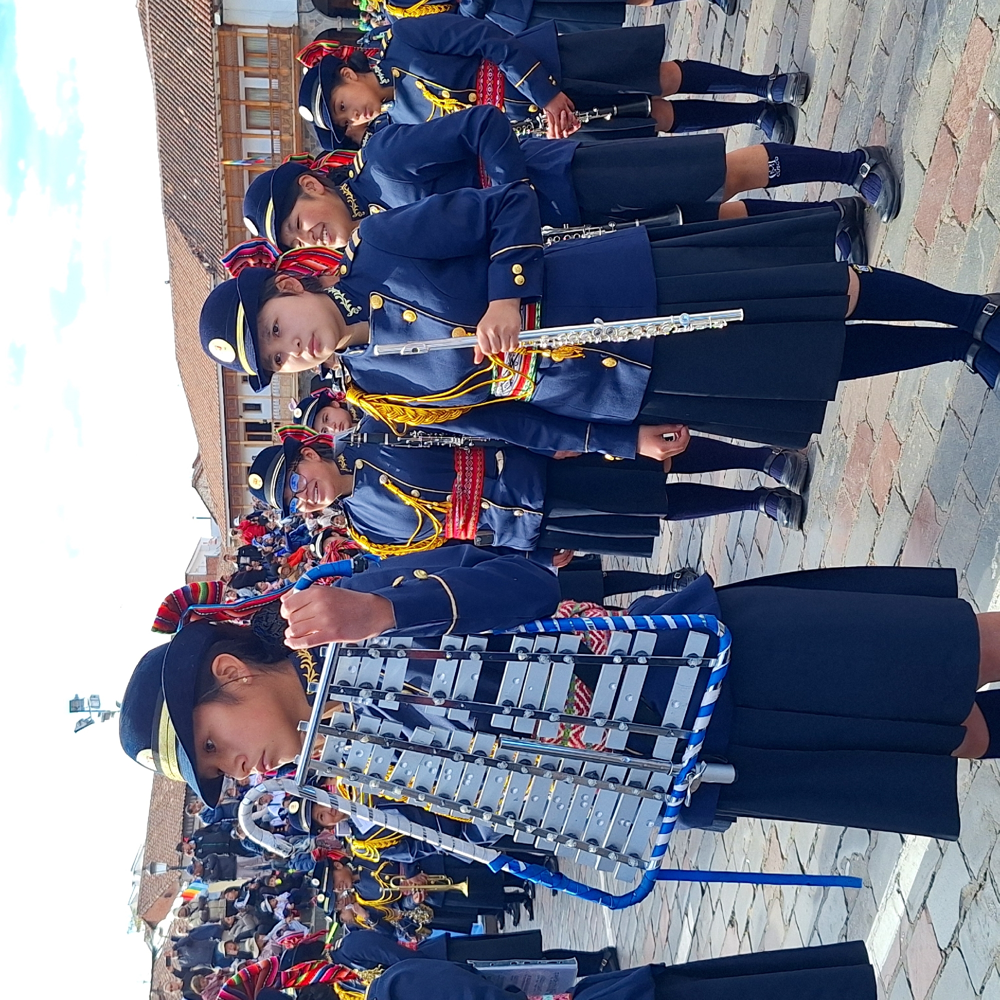 Youth marching band parades through historic Cuzco streets