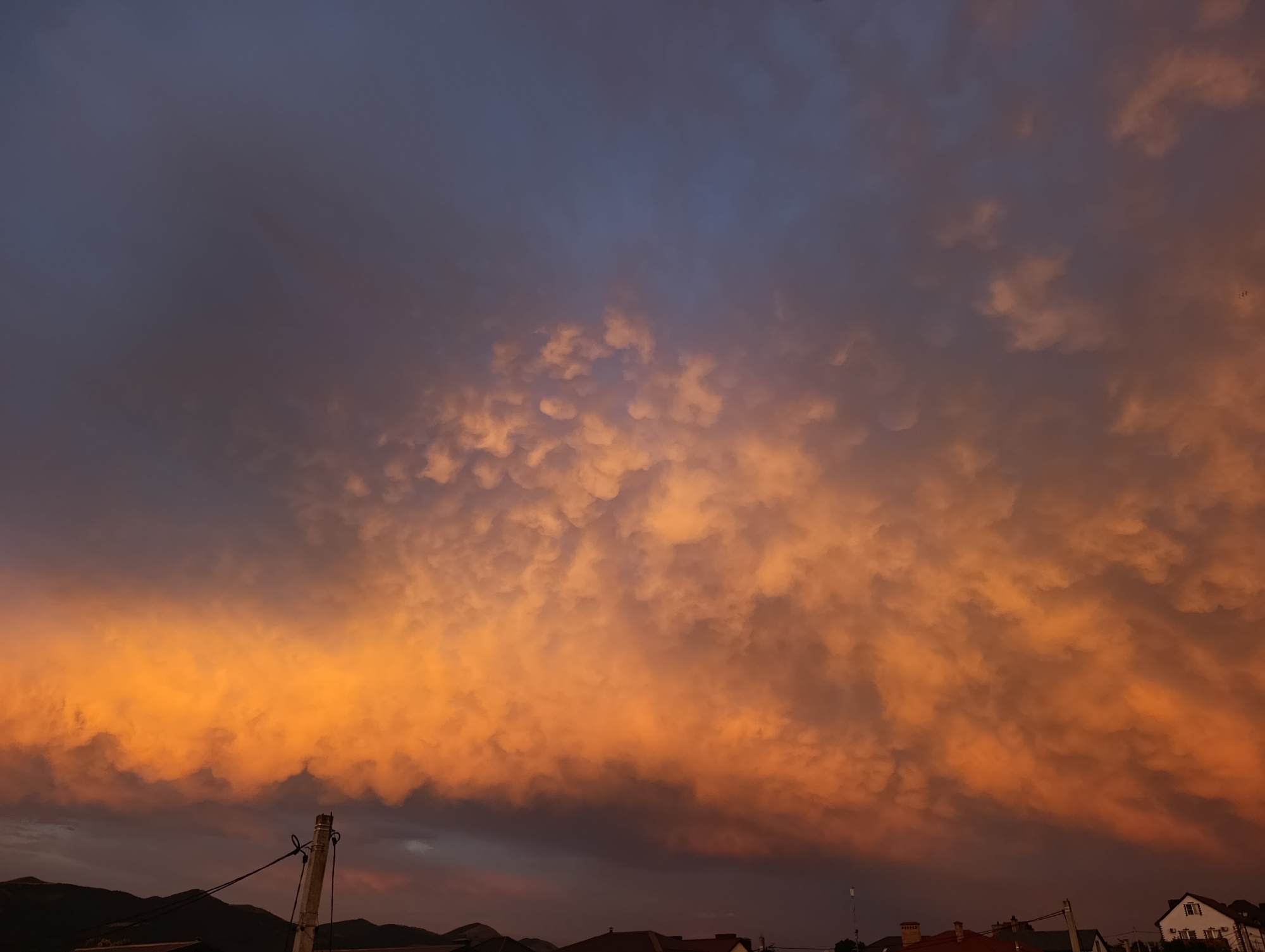 Vivid sunset sky over residential rooftops at dusk