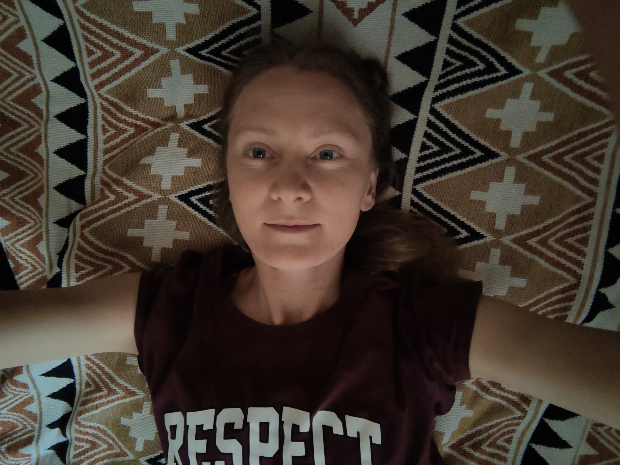 Woman rests on blanket near dried herbs in Ukrainian village