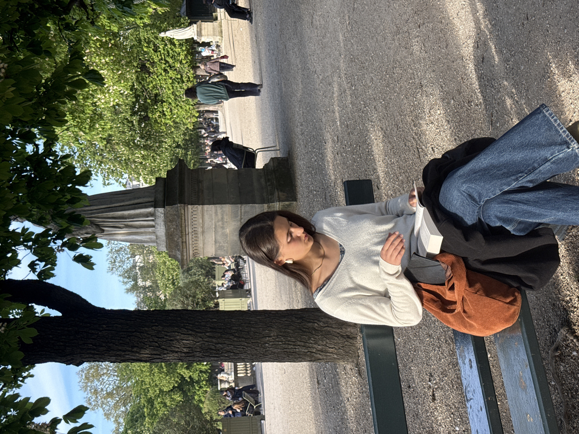 Woman sits on bench in Paris's Luxembourg Gardens
