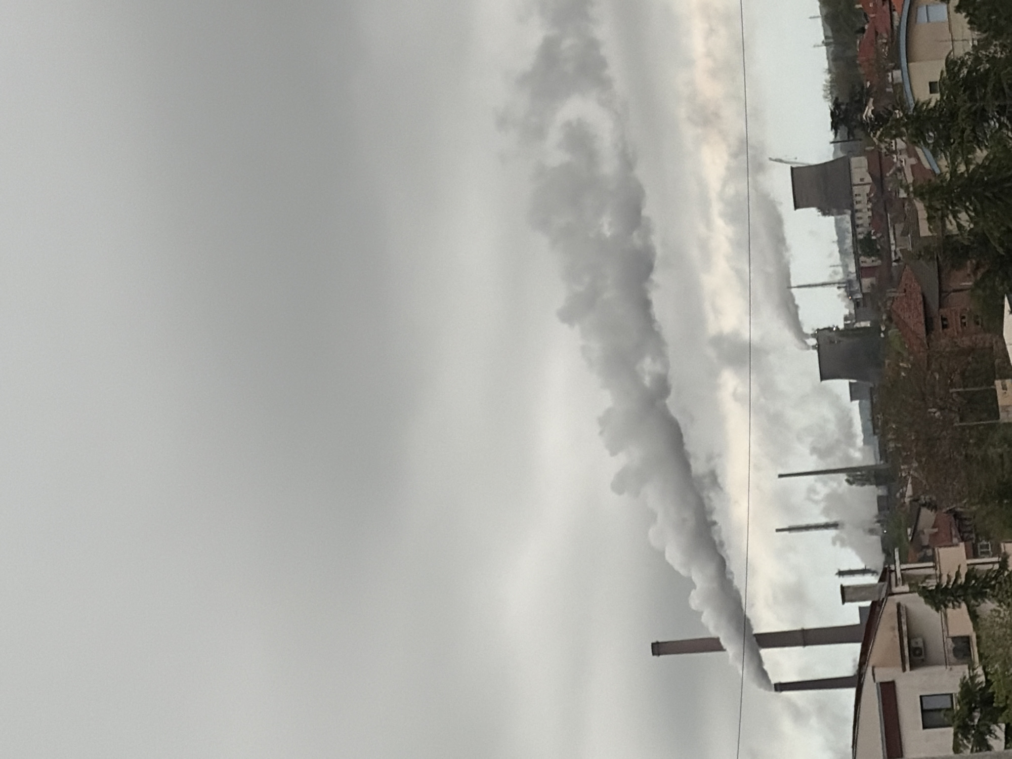 Industrial landscape with smokestacks observed under grey skies
