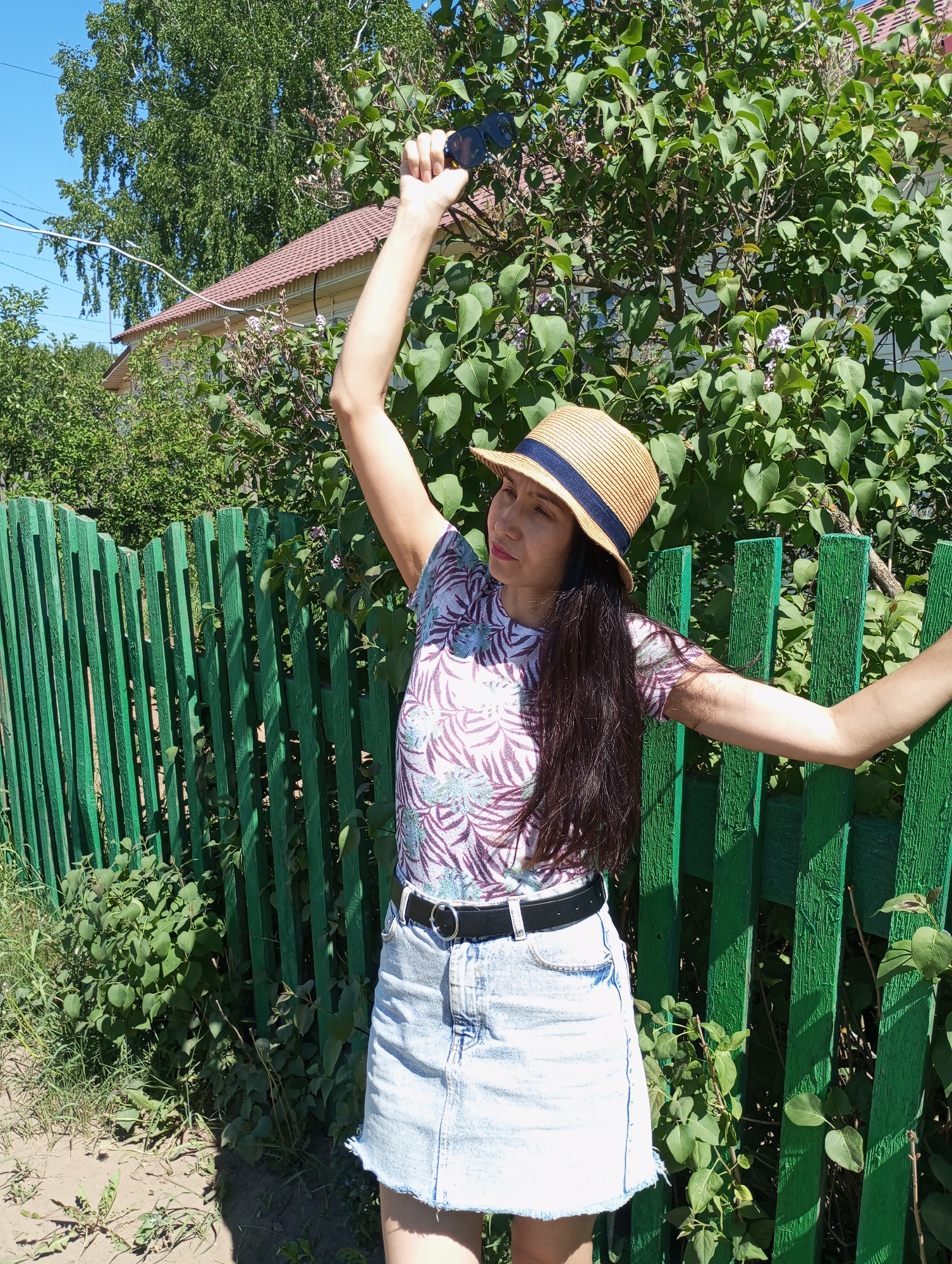 Woman documents sunny day in Russian village with photos, art
