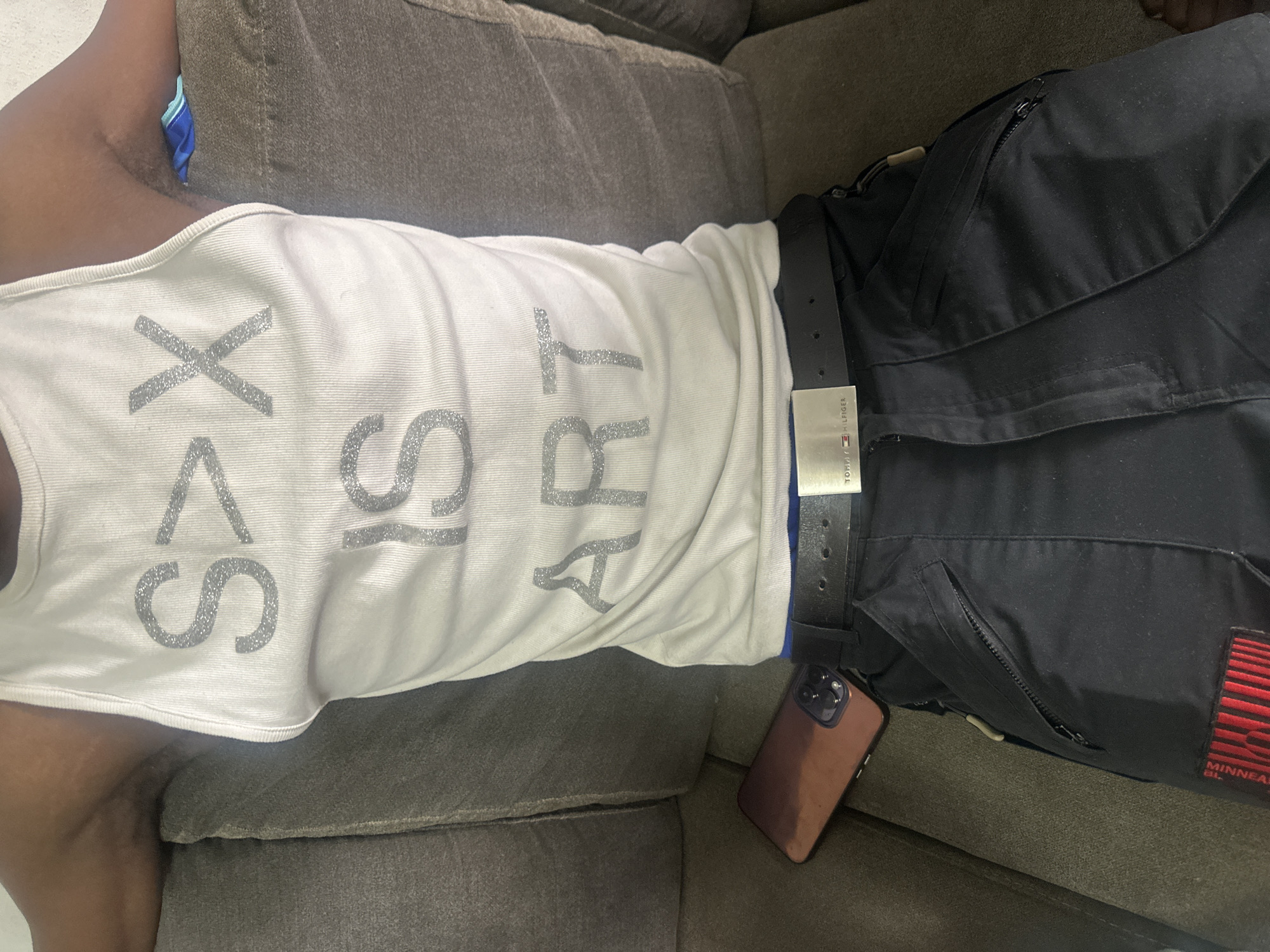 Person photographed relaxing on couch in Abuja with art-themed shirt