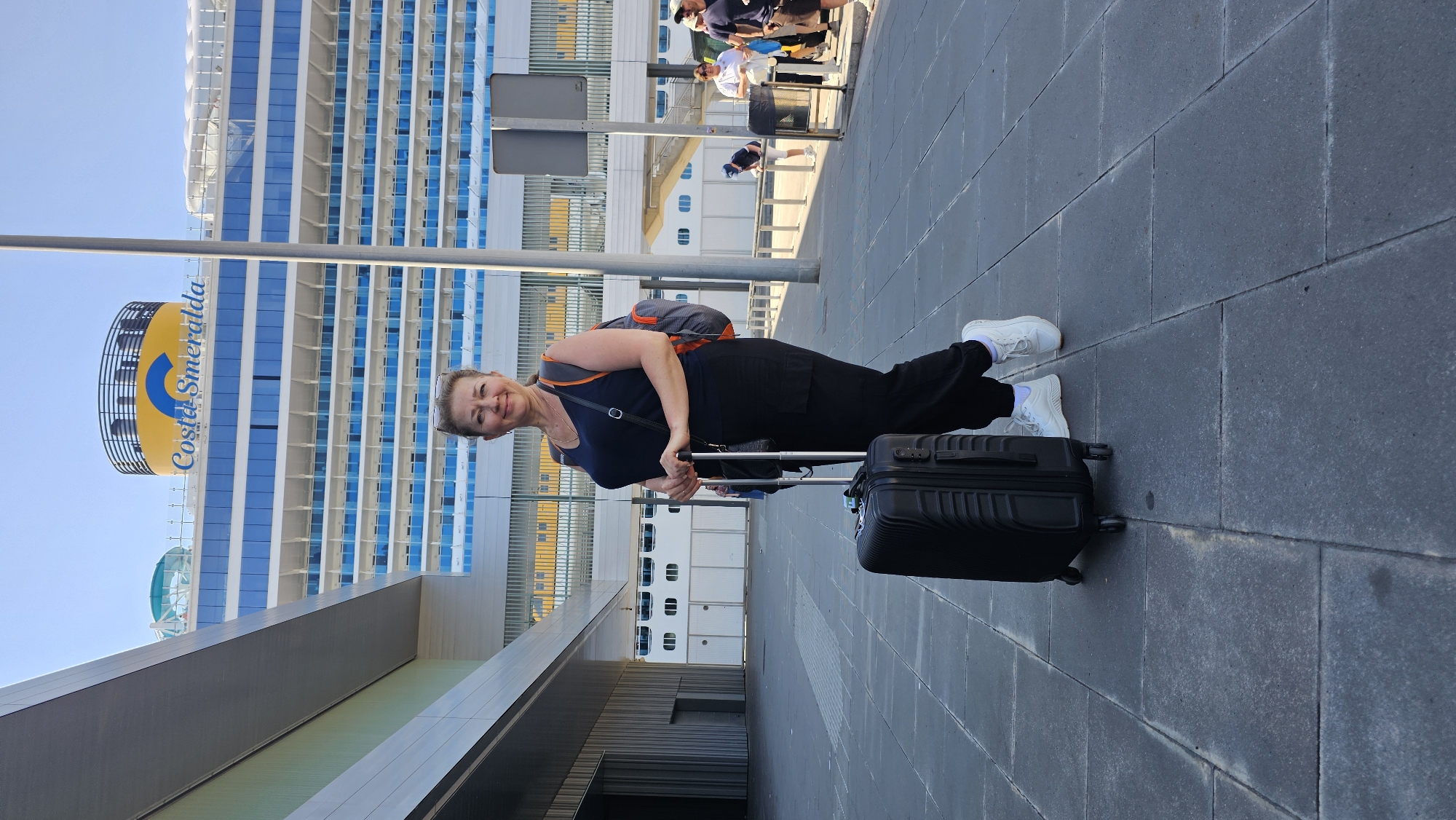 Cruise passengers transit Barcelona port terminal with docked ships