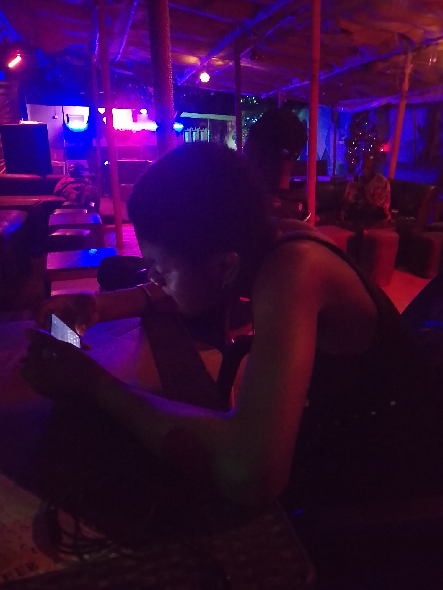 Person uses phone in colorfully lit indoor space