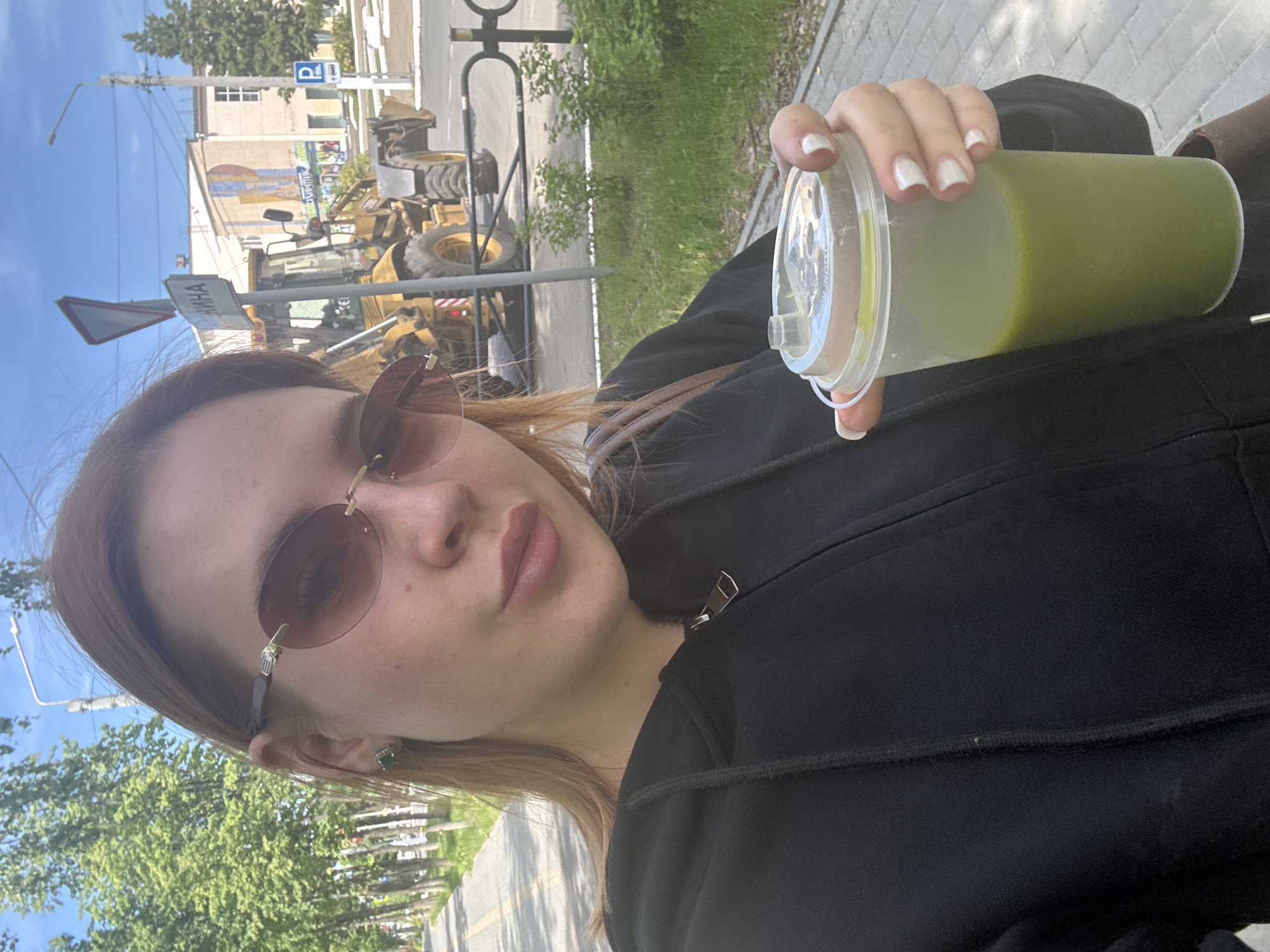 Woman takes selfies, walks with drink in Chaikovsky