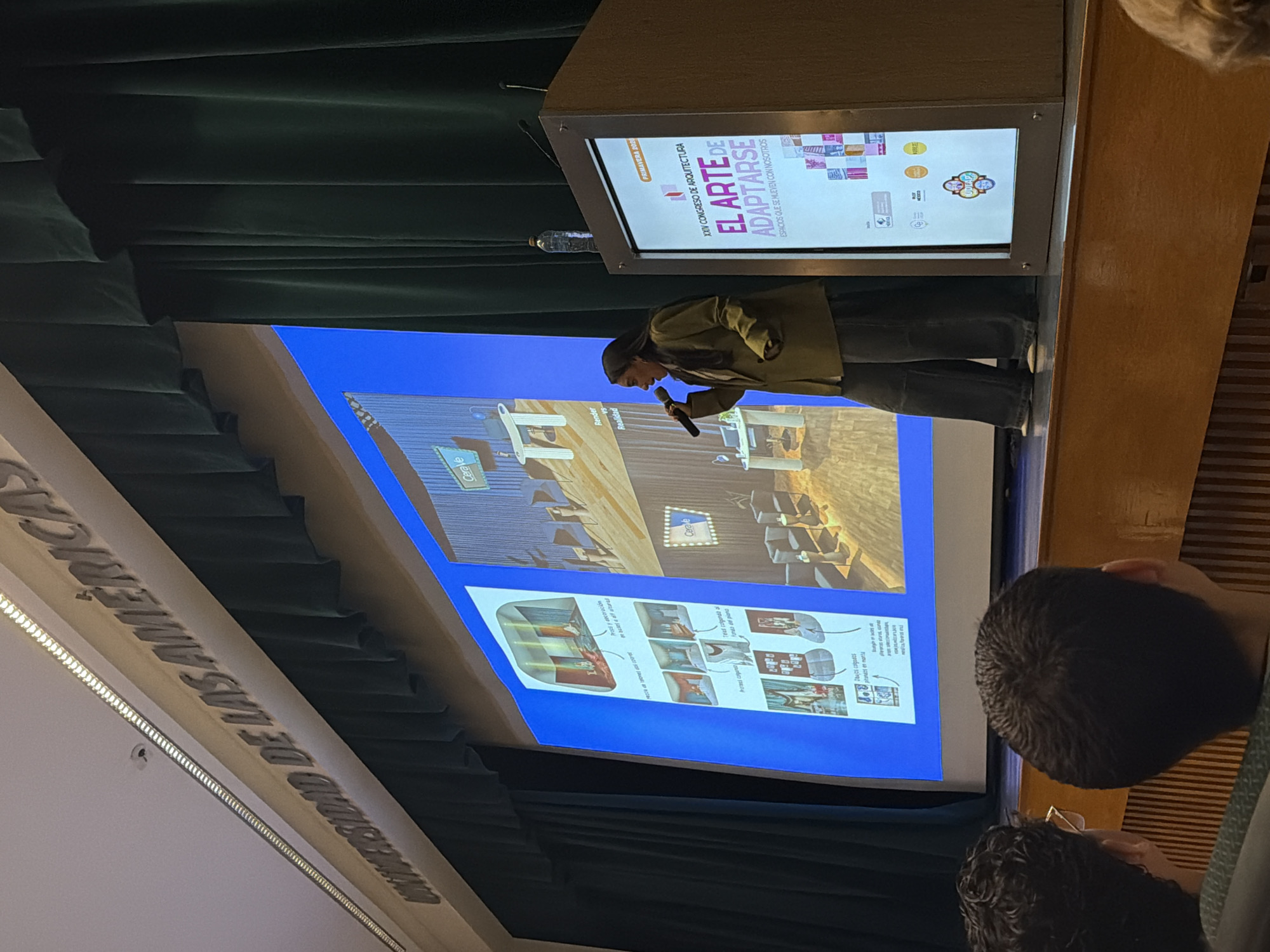 Person gives presentation at podium with microphone and screen