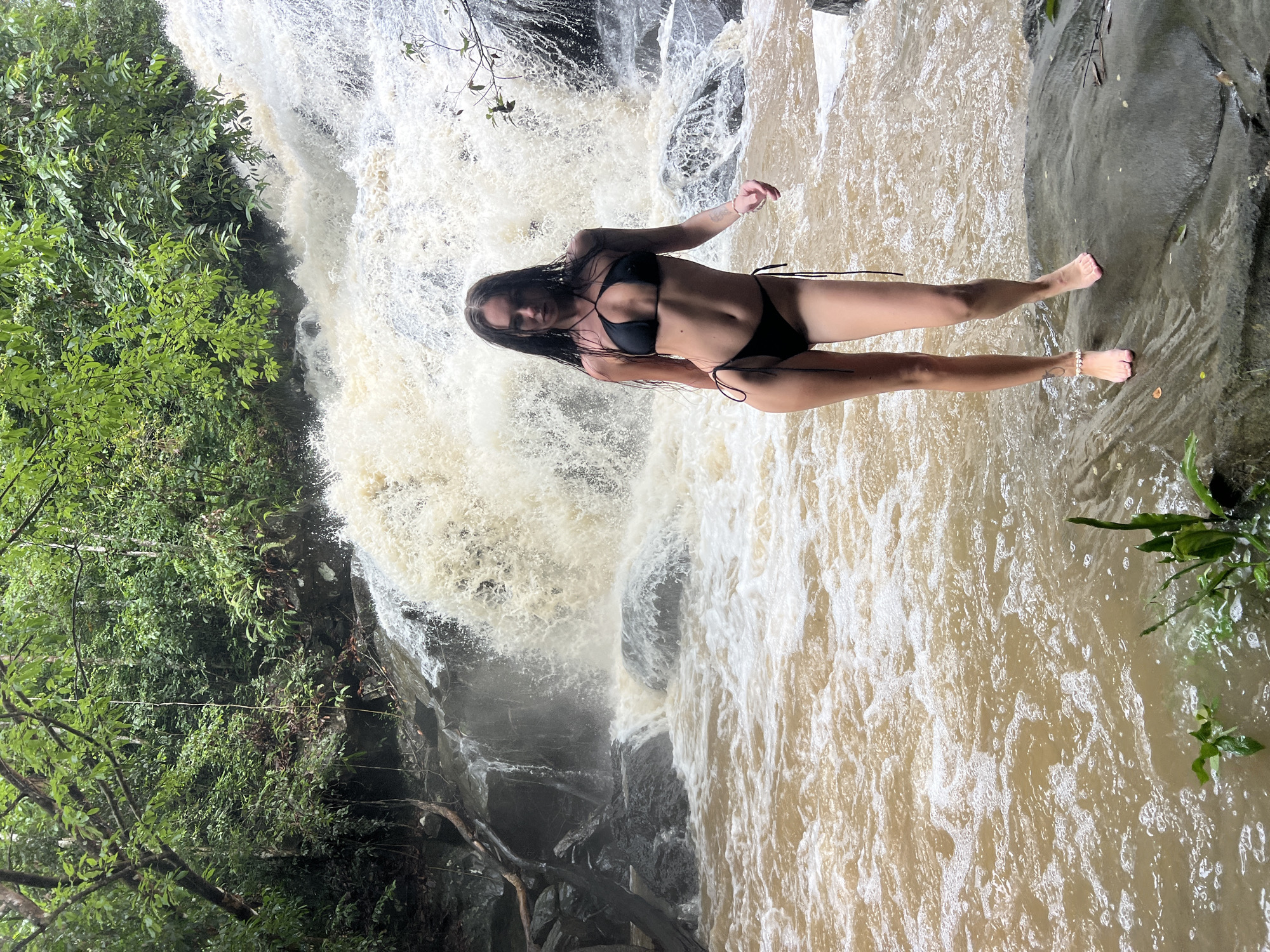 Woman poses at waterfall in Pitabeddara, Sri Lanka