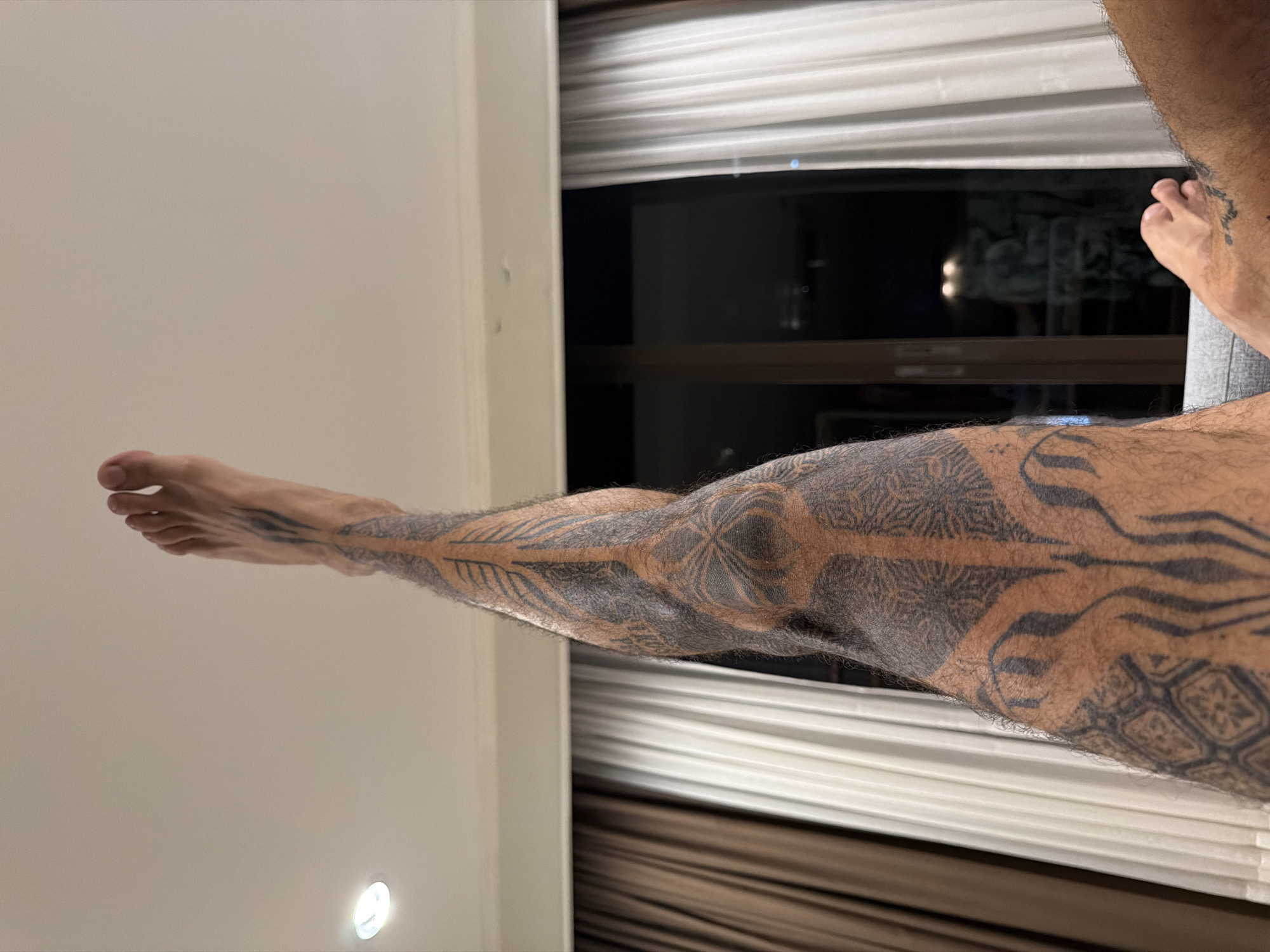 Tattooed man photographed lying on surface in Bangkok