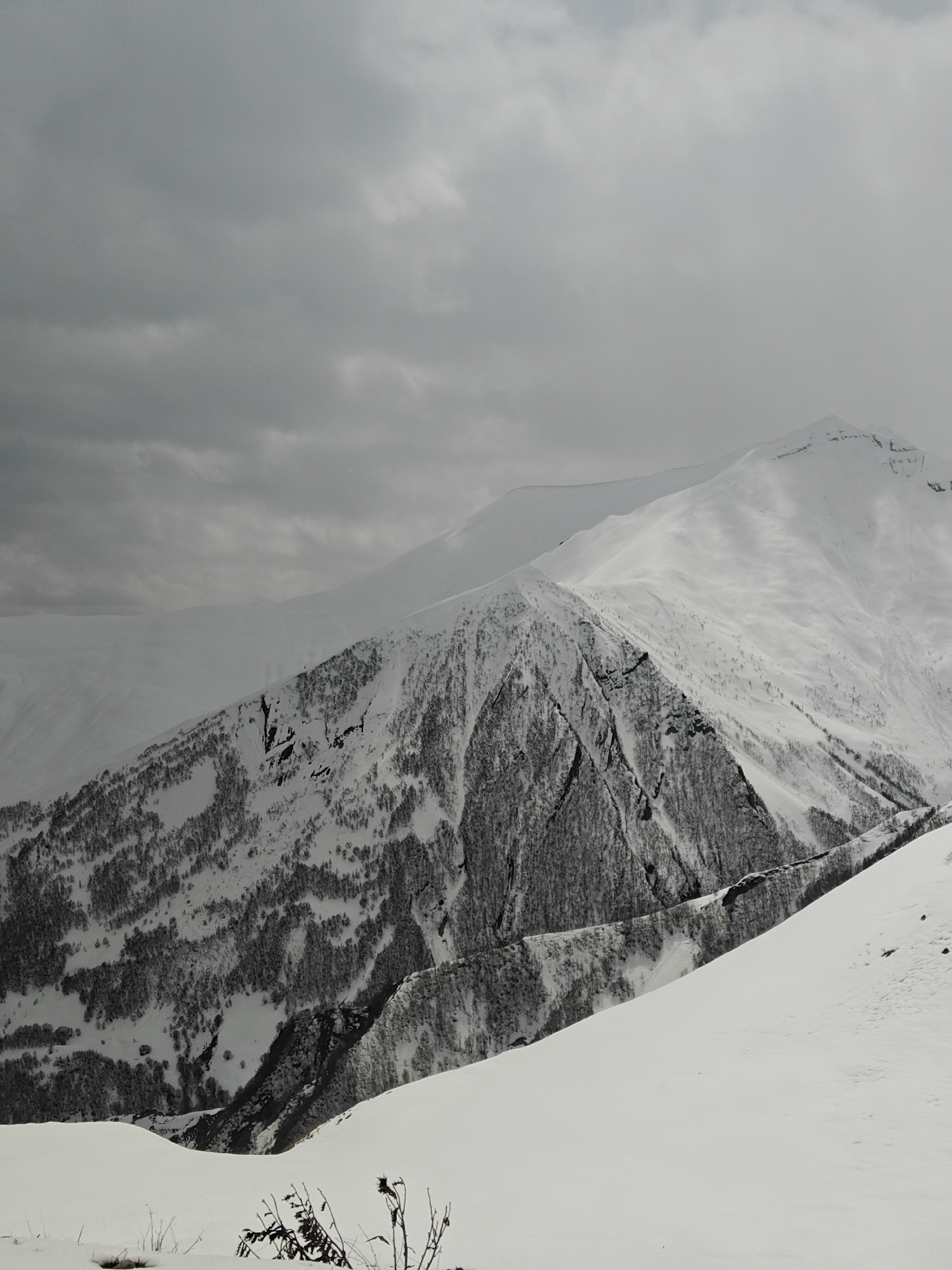 Overcast skies blanket snow-covered mountains in Gudauri, Georgia