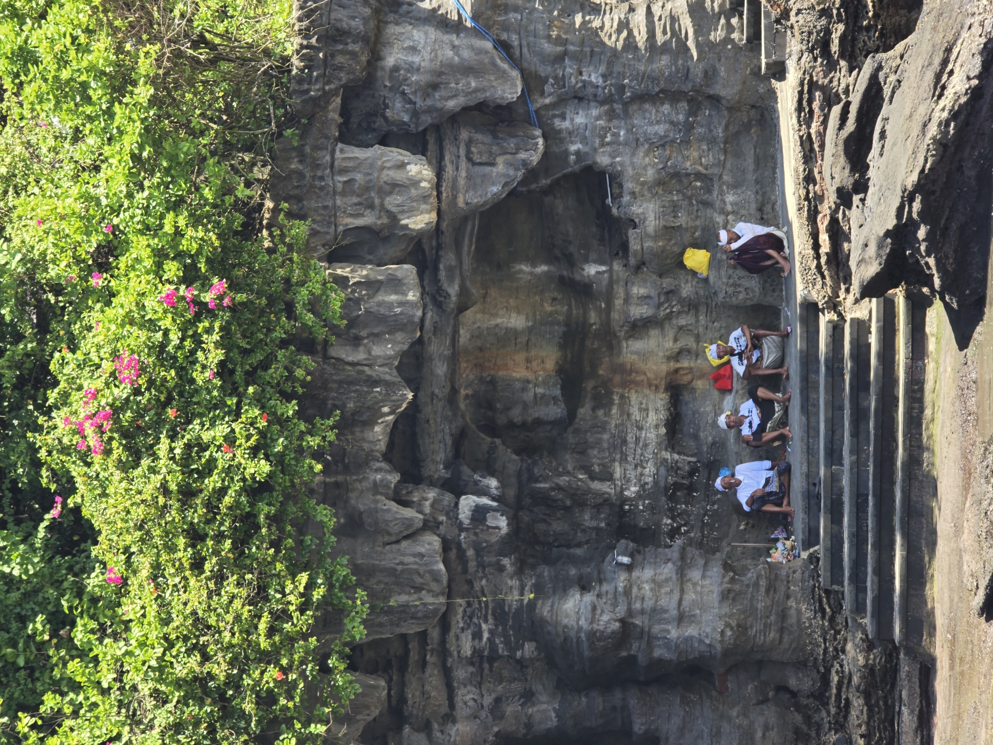 Visitors explore coastal temple complex and dramatic rock formations