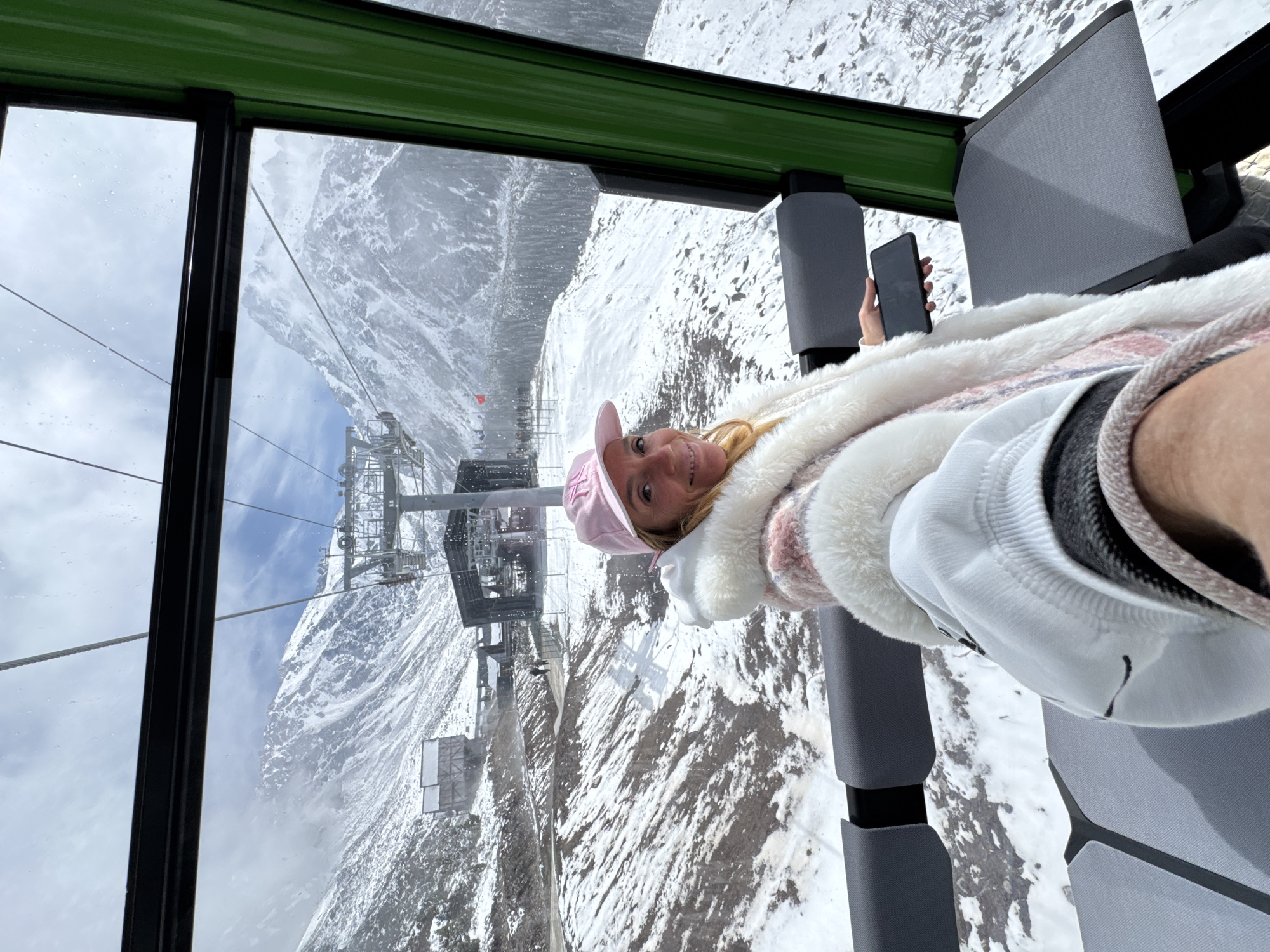Woman takes selfie during cable car ride in snowy Kyrgyzstan mountains