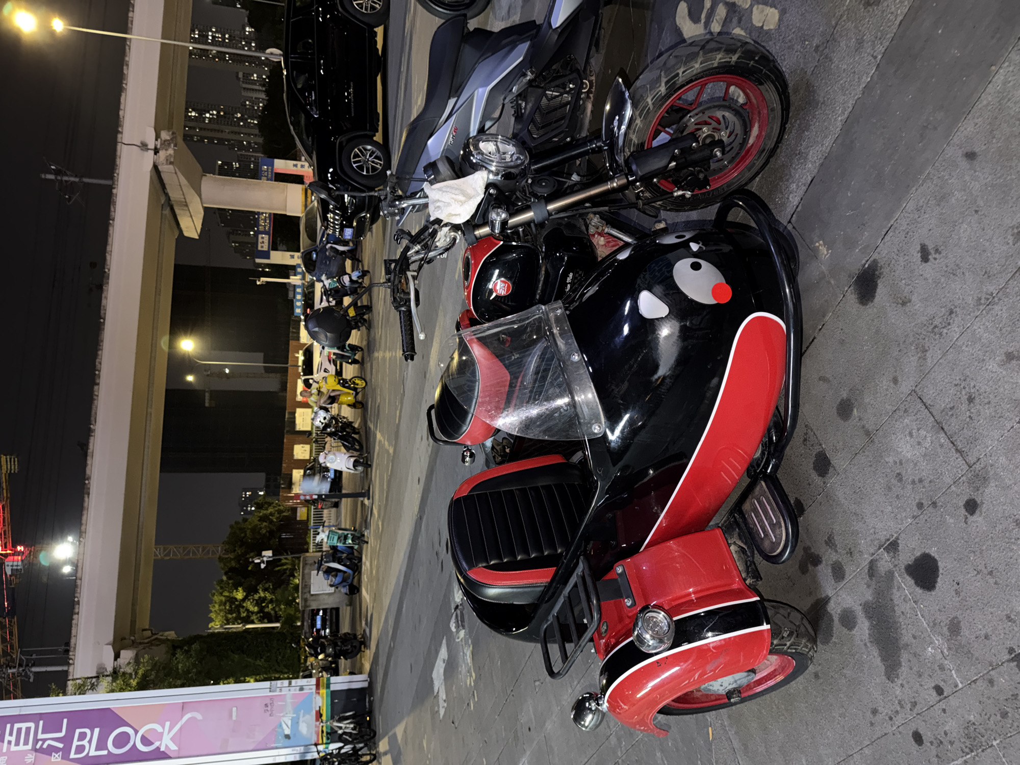 Panda sidecar motorcycle parked on a Chongqing street at night