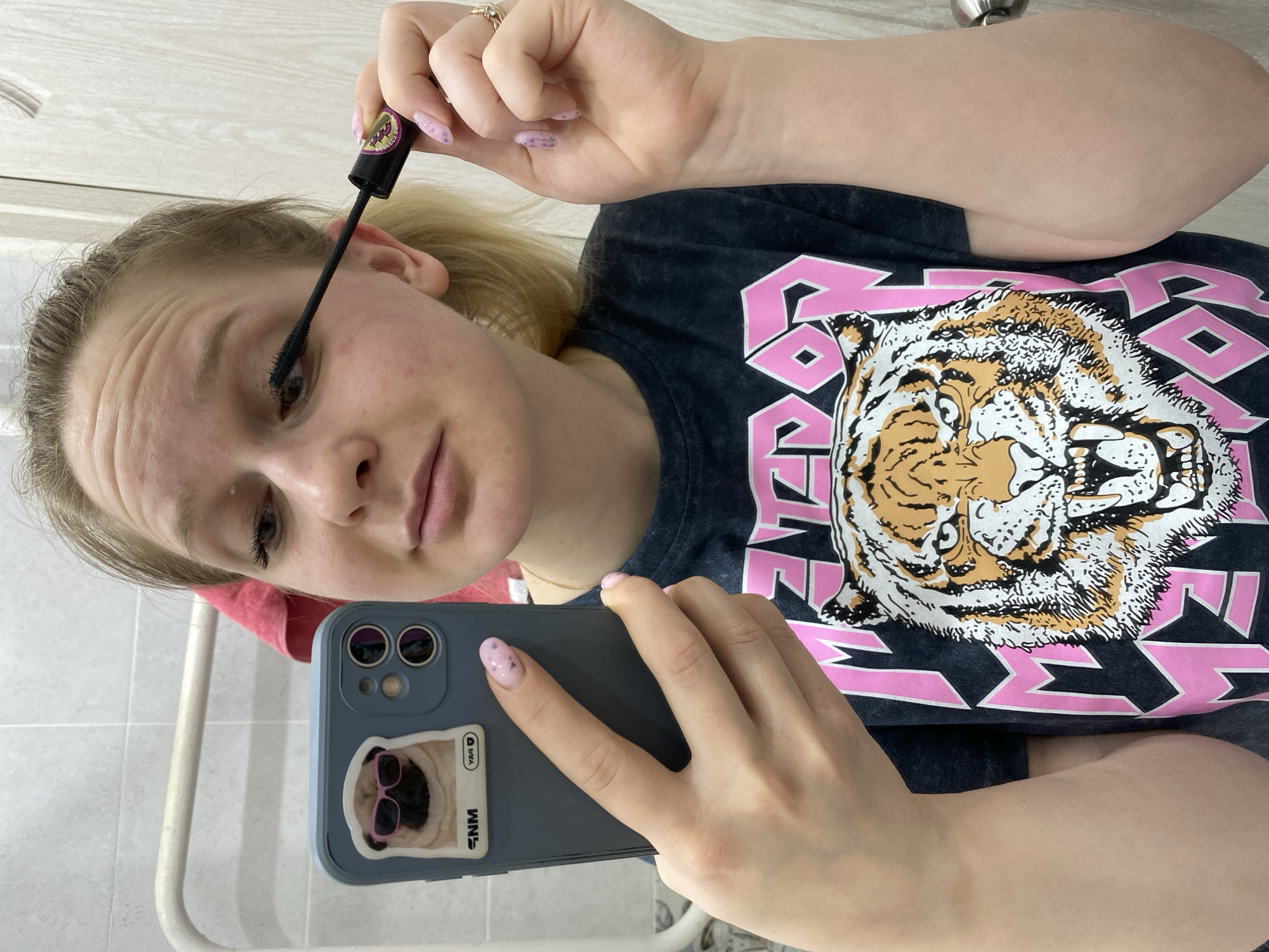 Woman documents makeup routine via bathroom selfie in Chaikovsky