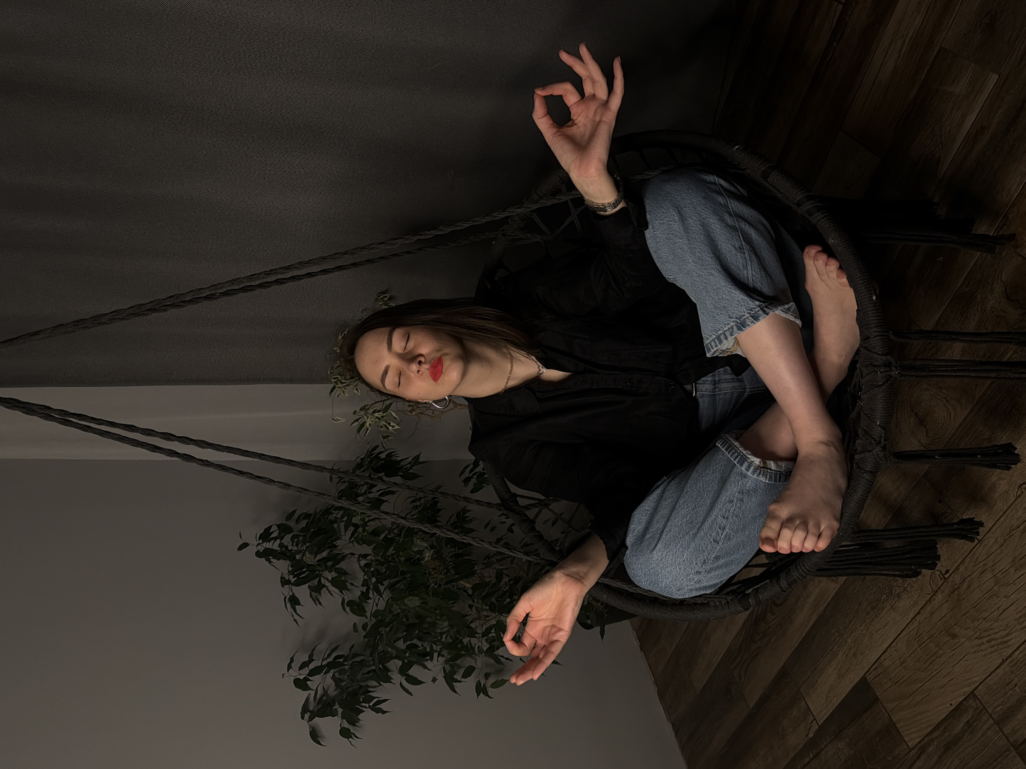 Woman relaxes in hanging chair in Chaikovsky home