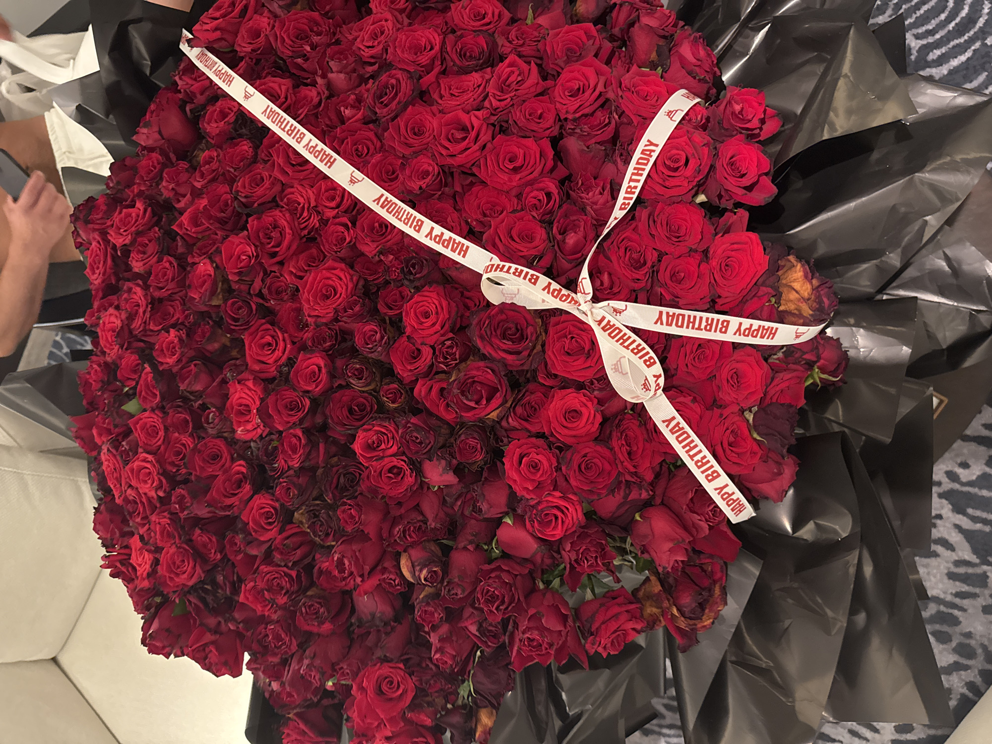 Hotel room birthday celebration captured with roses and ribbons