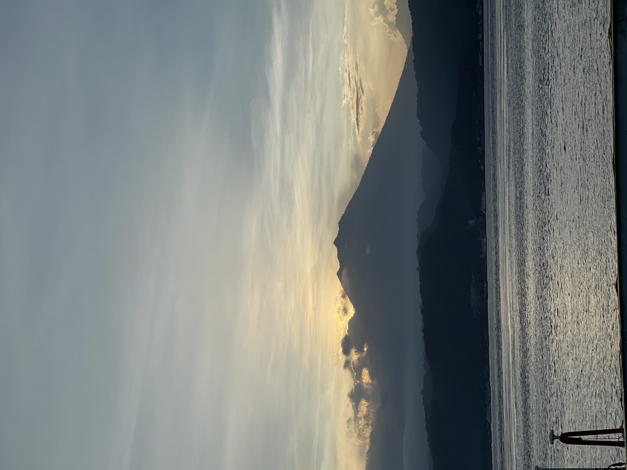 Golden sunrise illuminates Indonesian mountains and water